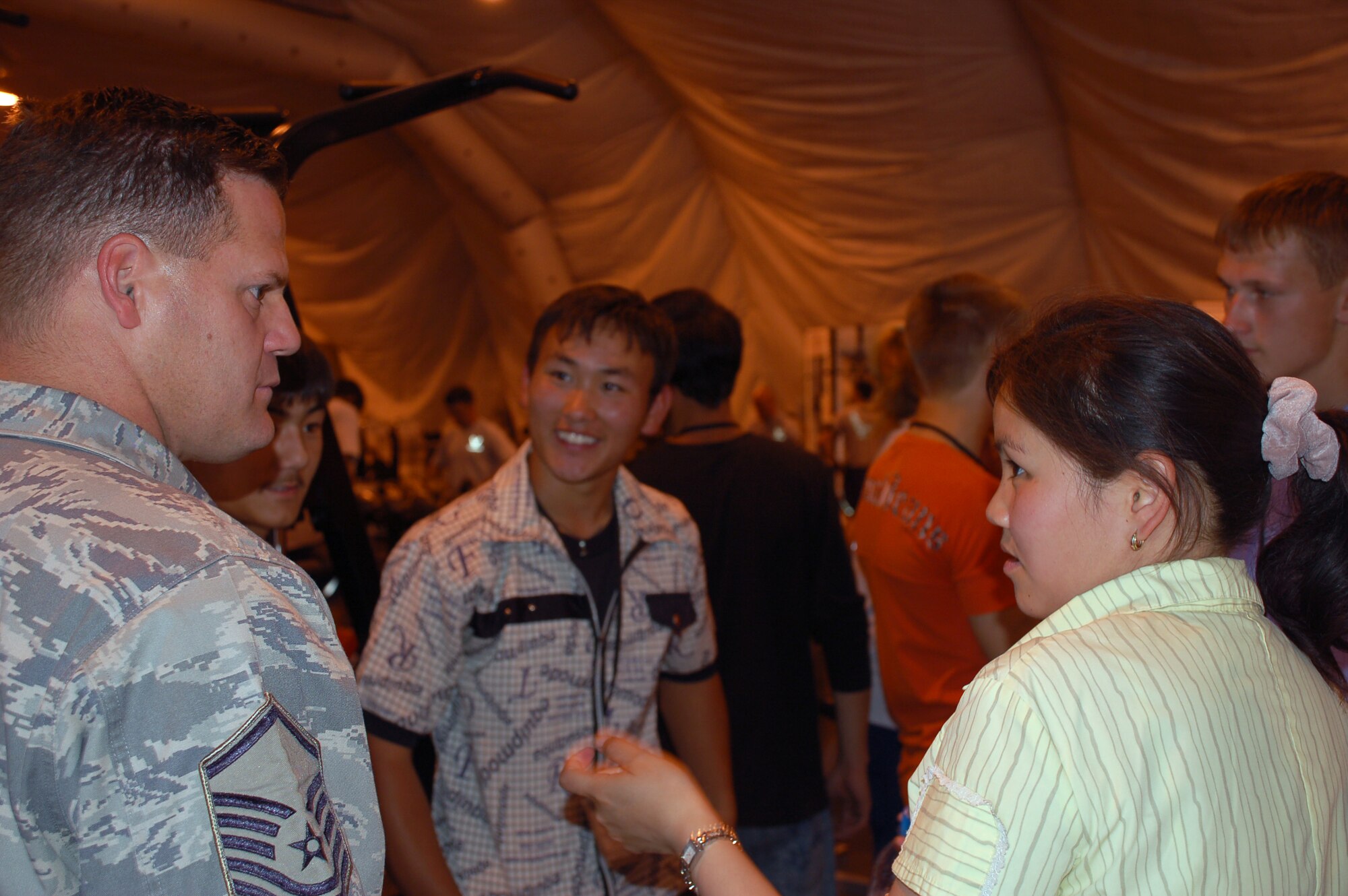(08/05/15)  Master Sgt. Ernest Ridings, 376th Expeditionary Force Support Squadron fitness center superintendent, talks with students from the local Jany Pahkta Village.  The students, ranging from 16 to 17 years of age, visited the recreation and welfare facilities run by the 376th EFSS. (U.S. Air Force/ Lt. Col. Adriane Craig)