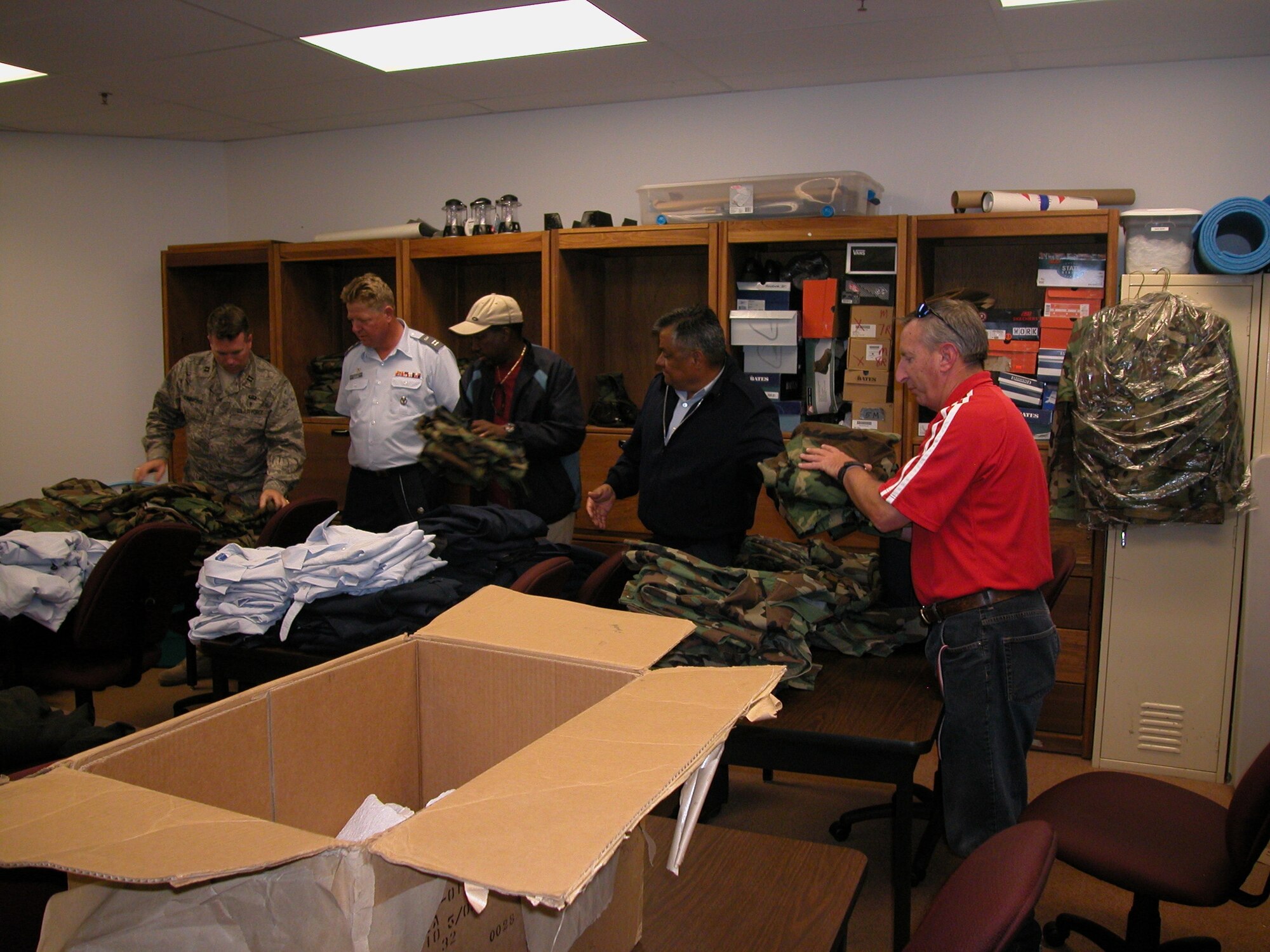 Captain Robert Simmons, left, vice president of the ROA chapter at March ARB, sorts through various uniforms with the Junior ROTC instructors. Captain Dave Goode, CAP, second from left, helped organize the uniforms. (U.S. Air Force photo by Maj. Don Traud, 452 AMW)