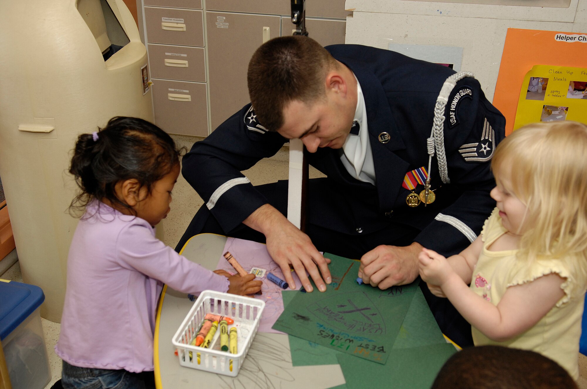 Staff Sgt. Adam Clonick, Drill Team Current Missions Coordinator, spends time coloring with kids at the Ellsworth AFB Child Development Center.  The AF Honor Guard Drill Team is the traveling component of the AF Honor Guard and tours world-wide representing all Airmen and showcasing USAF precision to recruit, retain, and inspire for the Air Force mission. (U.S. Air Force photo by Senior Airman Dan DeCook)(Released)
