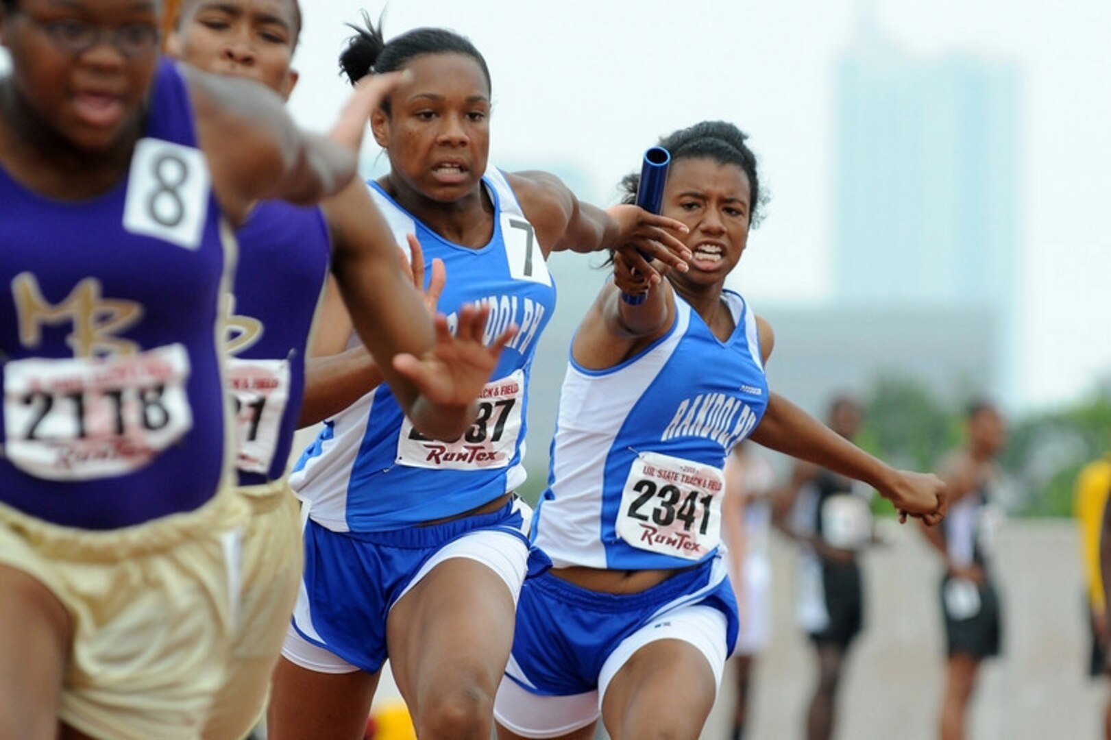 Sydney Solomon (right) hands off the baton to Jasmine Kent during the 400-meter relay at the Class 2A state track and field meet Saturday in Austin. (Photo by John Albright)