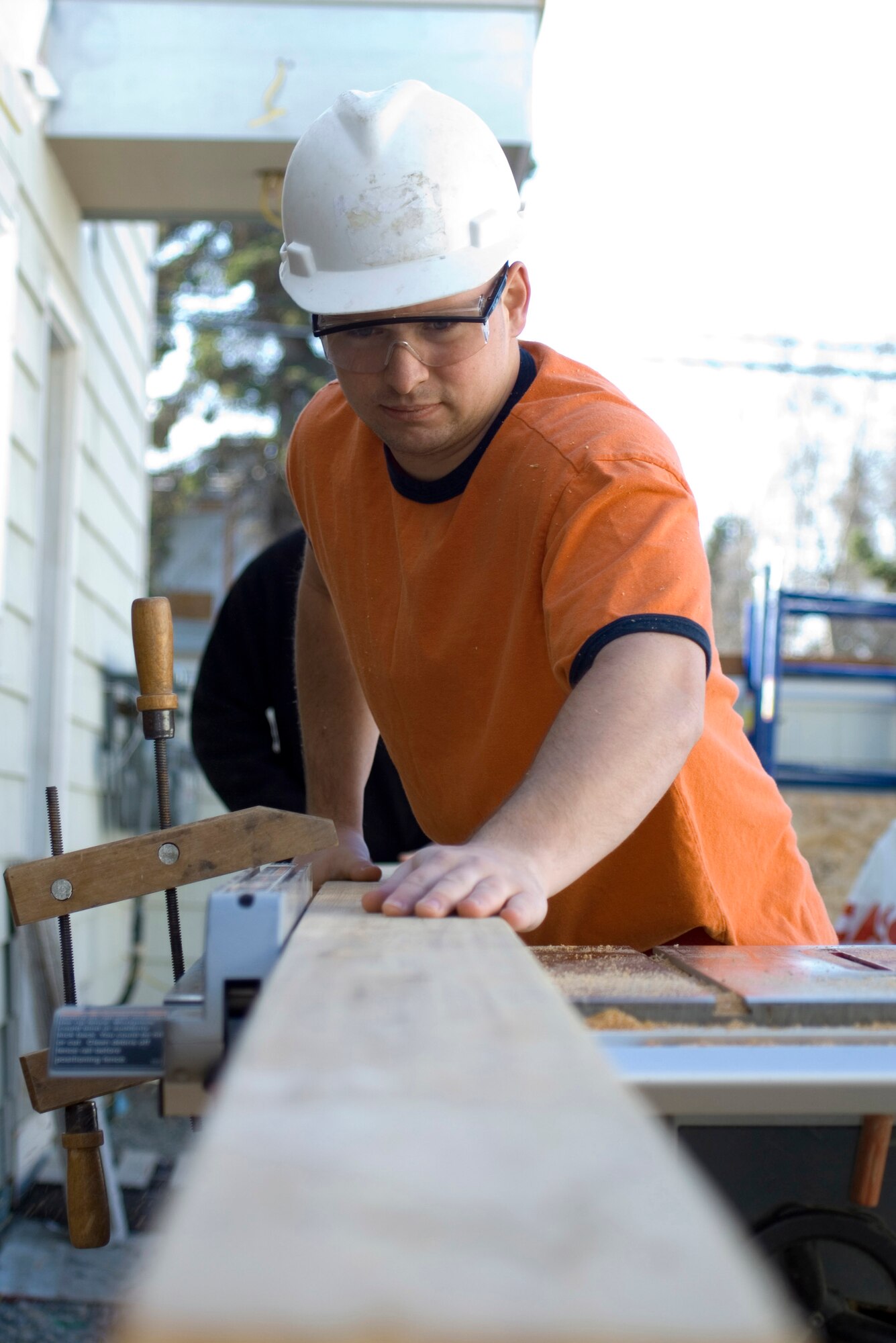 Staff Sgt. Michael McClary pushes lumber through a table saw at a Habitat for Humanity work site May 3 at Anchorage, Alaska. Sergeant McClary is the First Term Airman Center flight leader and a member of the 3rd Civil Engineer Squadron Structures Section at Elmendorf Air Force Base, Alaska. (U.S. Air Force photo/Airman 1st Class David Carbajal) 
