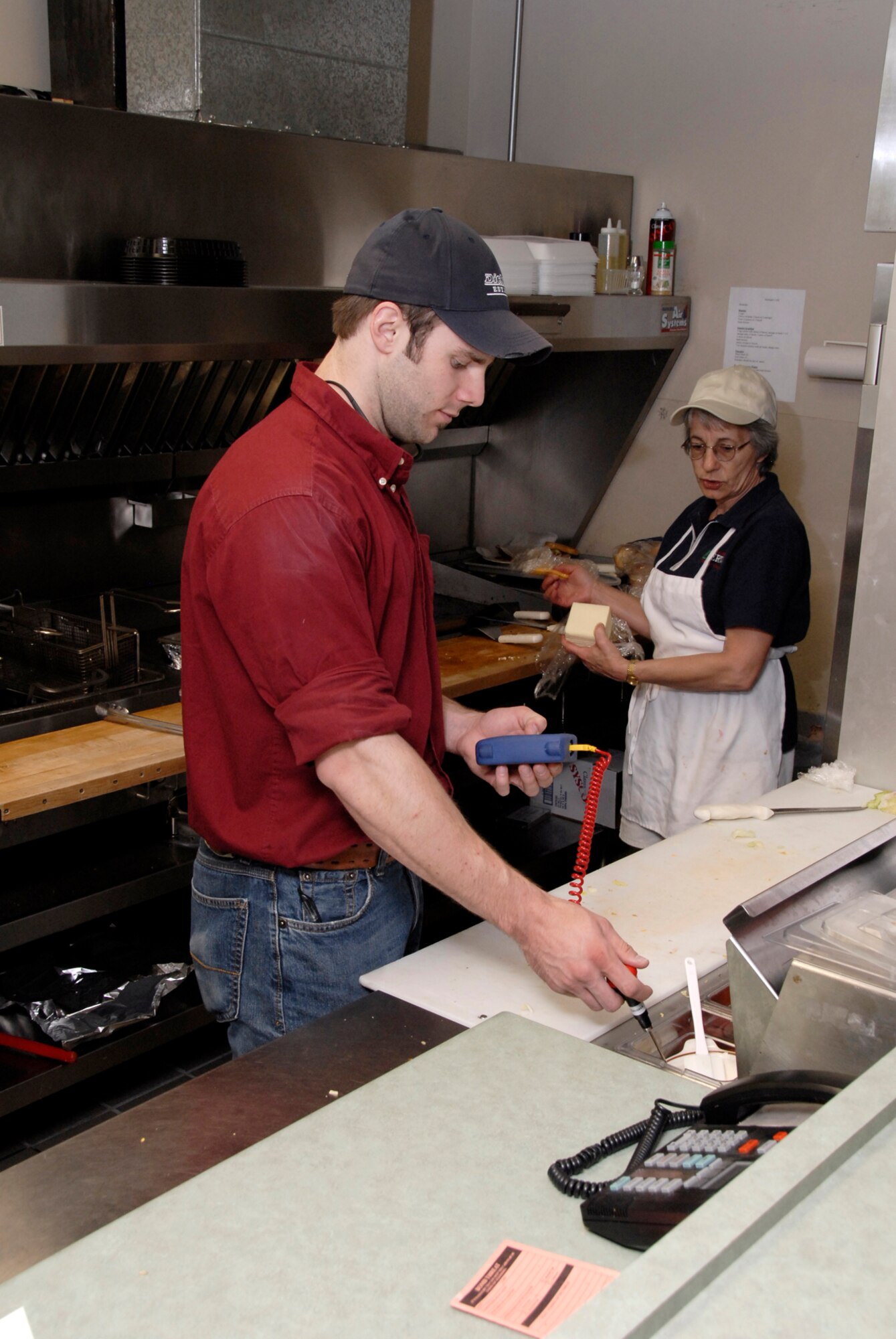 Justin Weibert, Aerospace Testing Alliance technical specialist with the safety and health group at Arnold Engineering Development Center, checks the temperature of the grill at Mulligan’sGrill at the Arnold Golf Course during an inspection. (Photo by Rick Goodfriend)