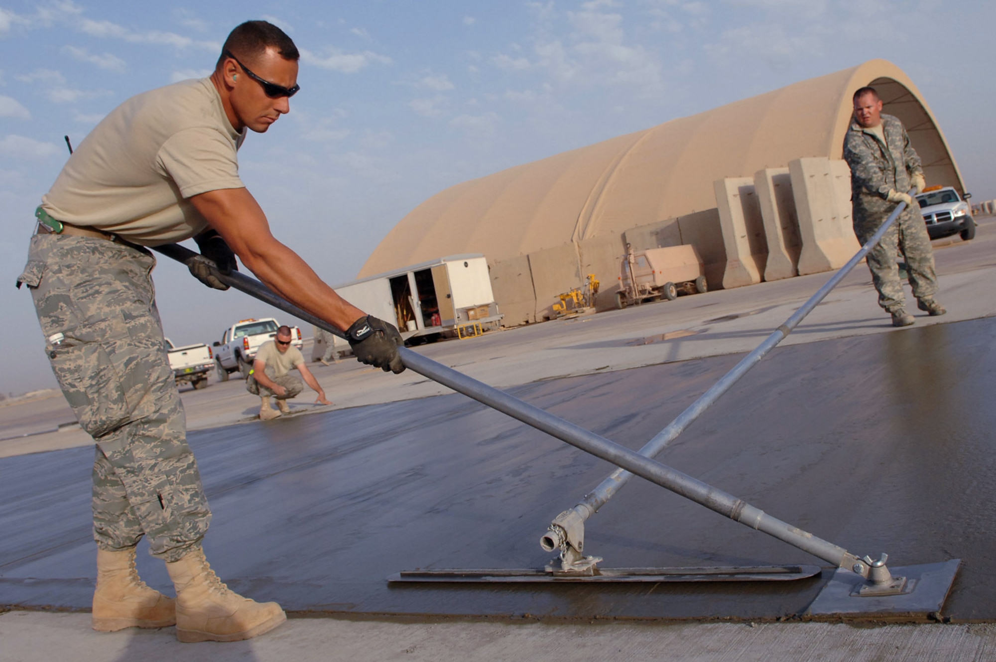 Tech. Sgt. Adam Brothers and Staff Sgt. Joshua Ralston smooth and edge a side of a concrete pad on the flightline May 13 at Balad Air Base, Iraq. Sergeant Brothers is deployed from Patrick Air Force Base, Fla.; Sergeant Ralston is deployed from Eielson Air Force Base, Alaska. Both are 332nd Expeditionary Civil Engineer Squadron heavy equipment operators. (U.S. Air Force photo/Senior Airman Julianne Showalter) 
