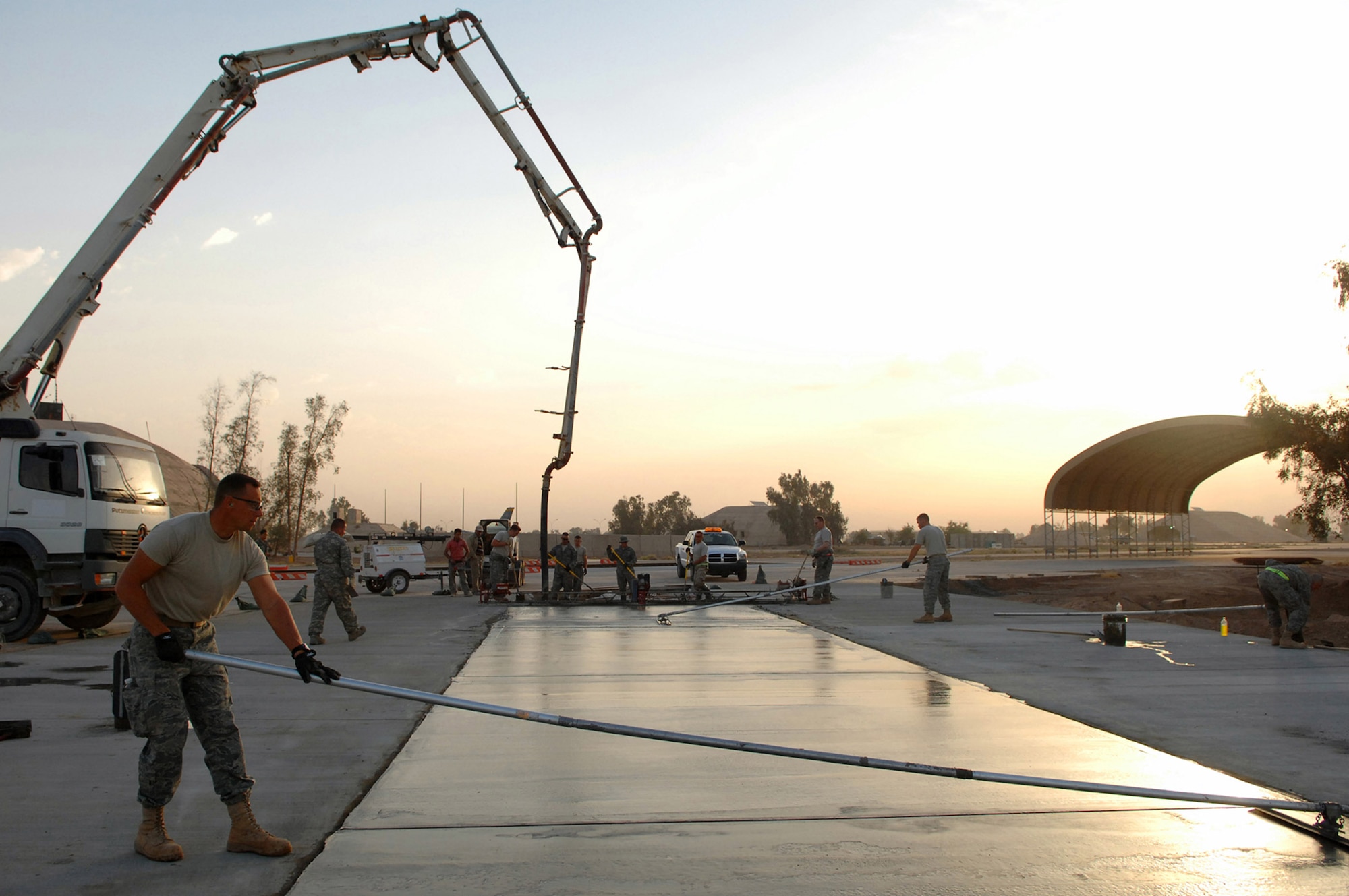 Tech. Sgt. Adam Brothers smoothes out a freshly poured concrete pad May 13 at Balad Air Base, Iraq. The pad is part of a massive extension project that will allow for more parking spots for various types of aircraft. Sergeant Brothers is a 332nd Expeditionary Civil Engineer Squadron heavy equipment operator deployed from Patrick Air Force Base, Fla. (U.S. Air Force photo/Senior Airman Julianne Showalter) 
