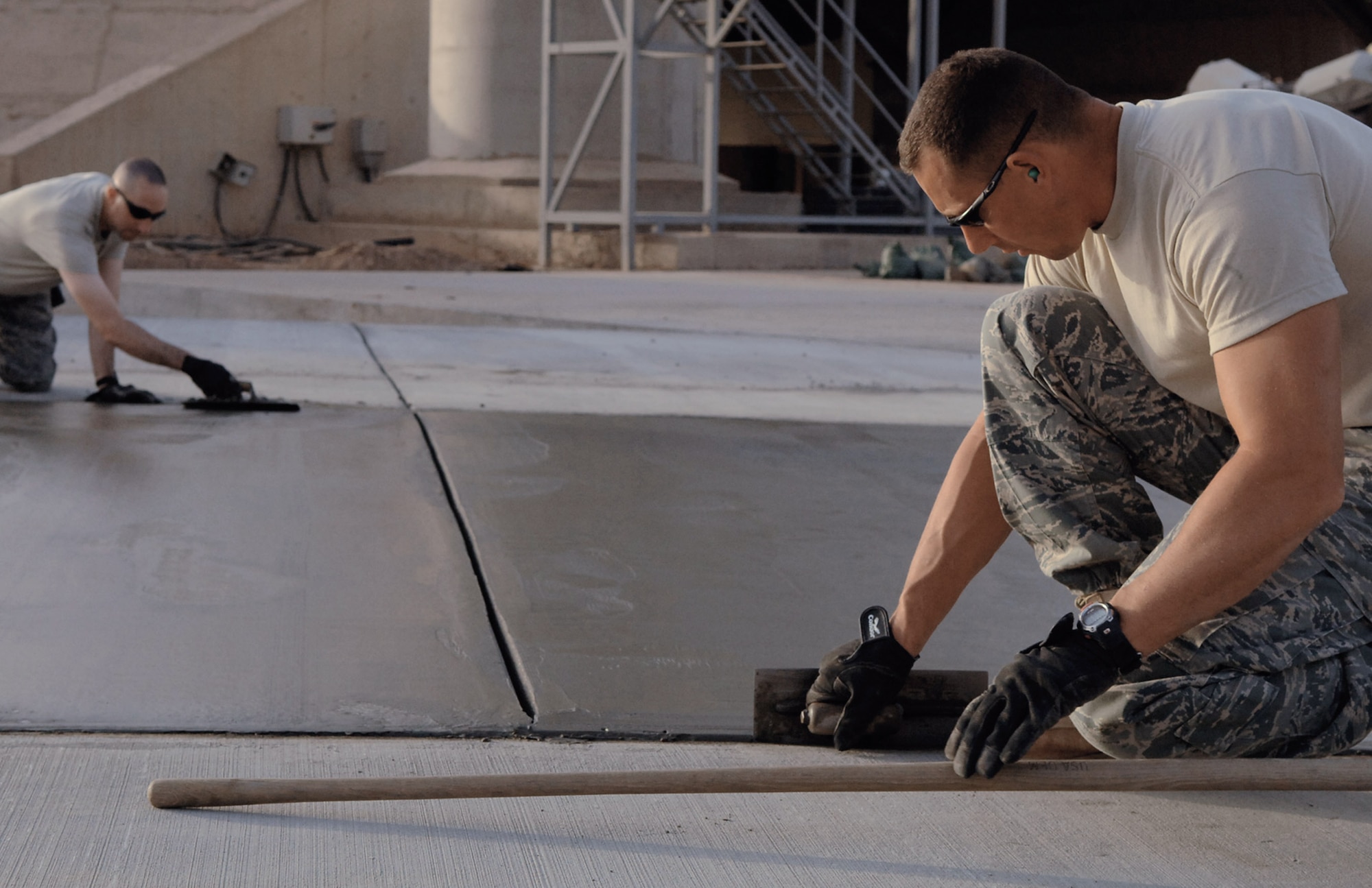 Tech. Sgt. Adam Brothers (right) and Master Sgt. Brian Nolan edge a new pad May 13 at Balad Air Base, Iraq. Sergeant Brothers is a 332nd Expeditionary Civil Engineer Squadron heavy equipment operator deployed from Patrick Air Force Base, Fla., and Sergeant Nolan is the 332nd ECES heavy repair noncommissioned officer in charge deployed from Ellsworth AFB, S.D. (U.S. Air Force photo/Senior Airman Julianne Showalter) 
