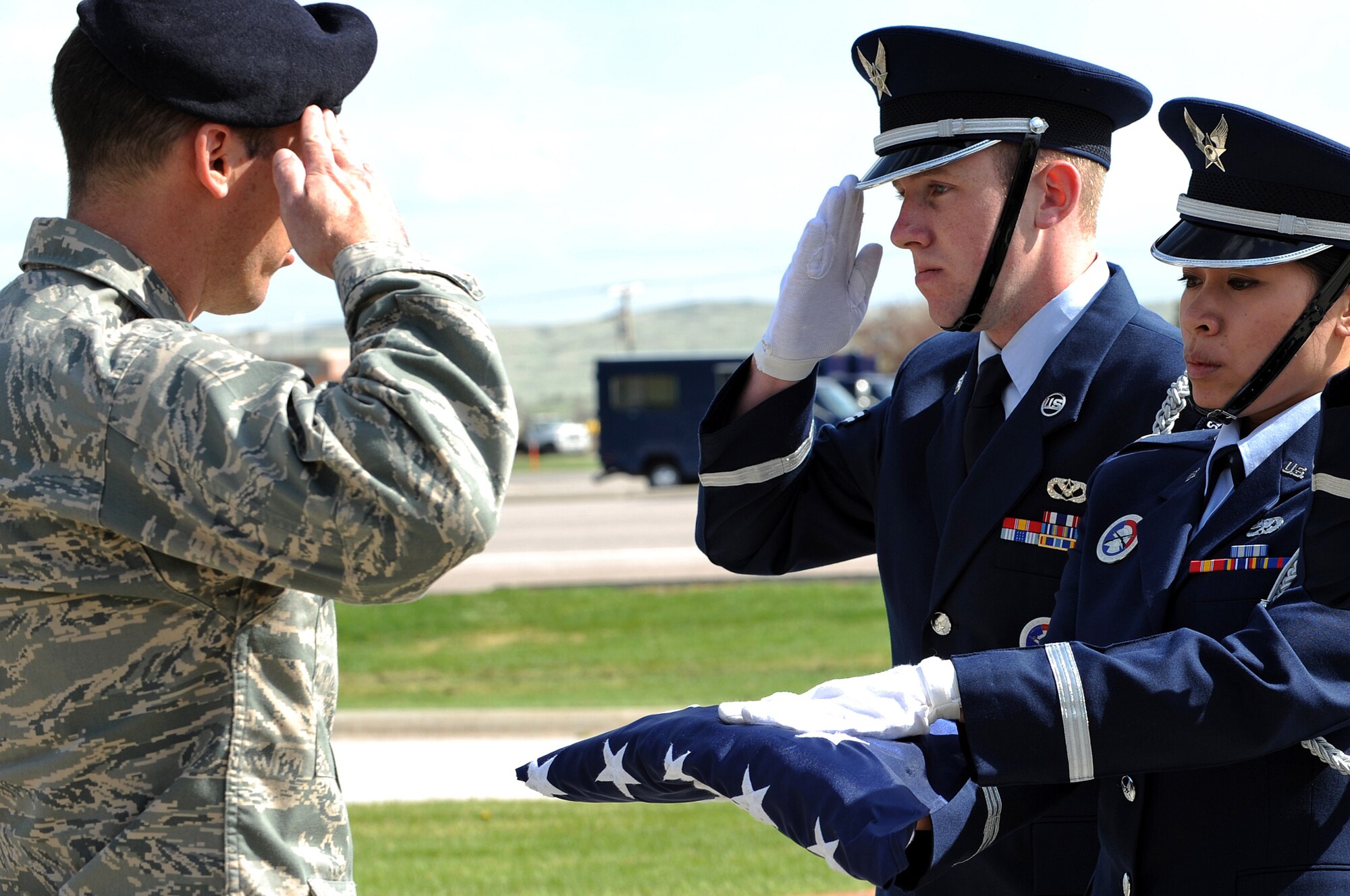 1st Lt. MaryAnn Nguyen, Ellsworth Honor Guard member, hands off the flag to Maj. Erik Bruce, 28th Security Forces Squadron commander, during the National Peace Officers Memorial Day retreat ceremony here, May 15. The National Peace Officers Memorial Day demonstrate to relatives, friends and colleagues of fallen officers that their sacrifice is not forgotten. (U.S. Air Force photo/Senior Airman Marc I. Lane)
