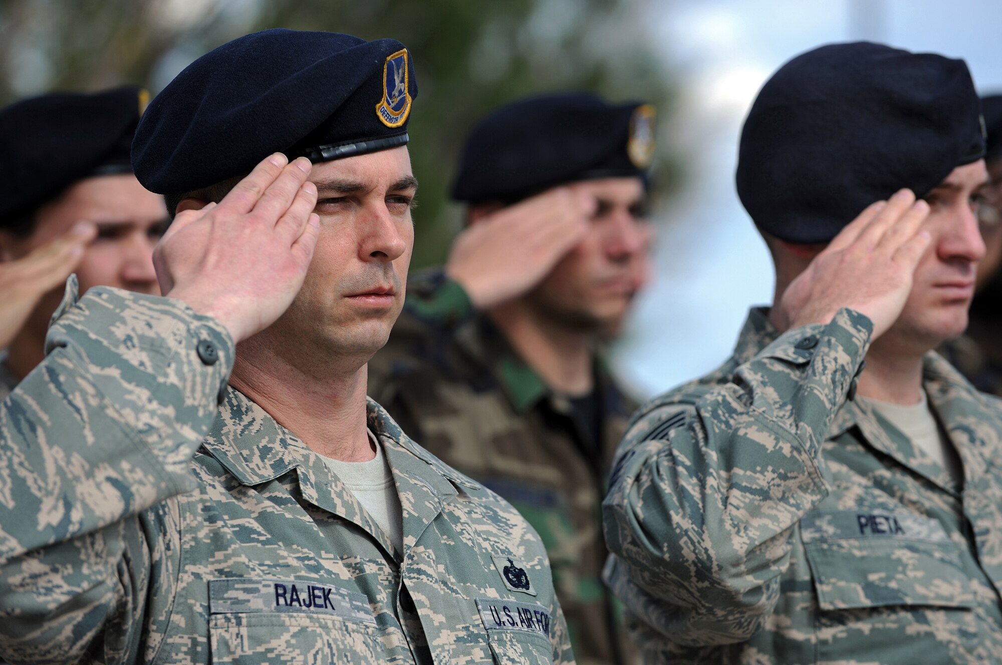 Tech. Sgt. Todd Rajek and Staff Sgt. Benjamin Pieta, 28th Security Forces Squadron members, and others from the 28 SFS salute the American flag during the National Peace Officers Memorial Day retreat ceremony here, May 15. The National Peace Officers Memorial Day is part of National Police Week. (U.S. Air Force photo/Senior Airman Marc I. Lane)
