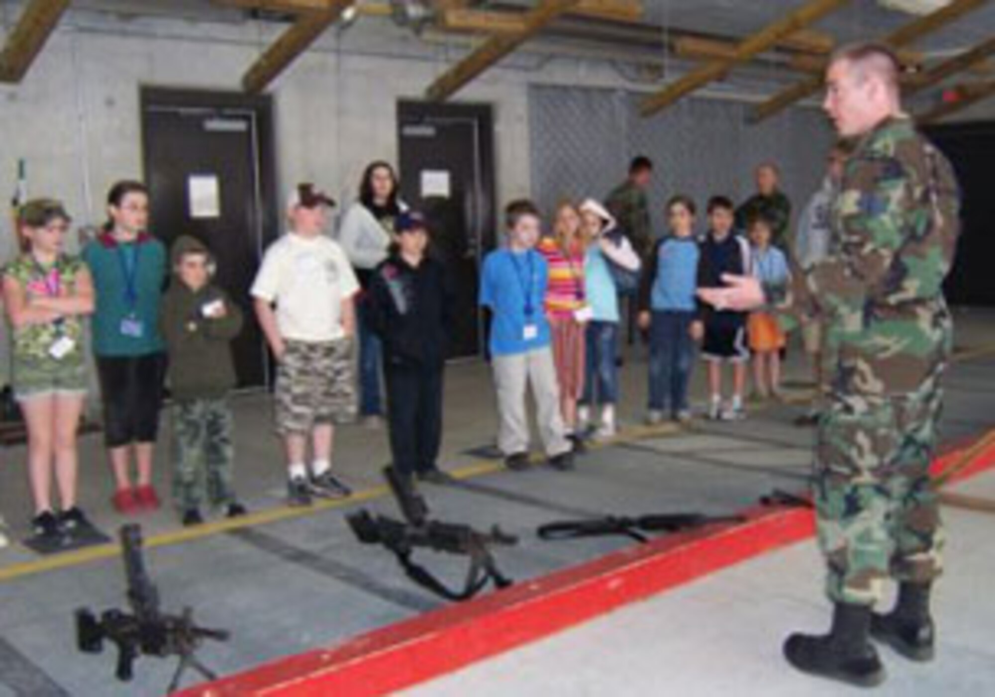 SSgt Thomas A. Addley, 174th Fighter Wing Combat Arms Apprentice gives the children a tour of the firing range