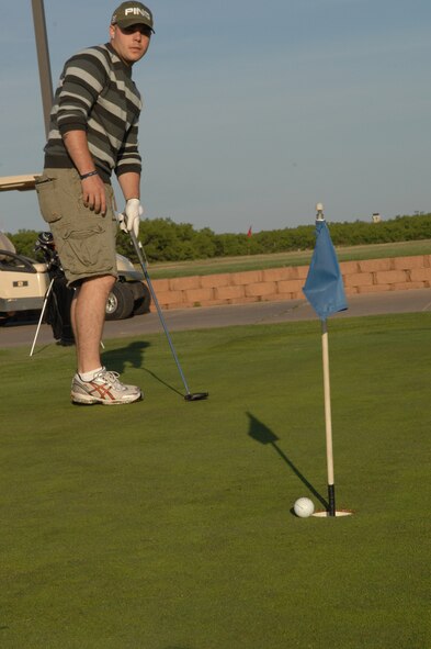 DYESS AIR FORCE BASE, Texas -- Airman 1st Class William Hinson, 7th Medical Support Squadron, practices his putting before a golf tournament May 16. The golf tournament was one of the many events Dyess celebrated during the annual Sports Day. (U.S. Air Force photo by Airman 1st Class Jennifer Romig)
