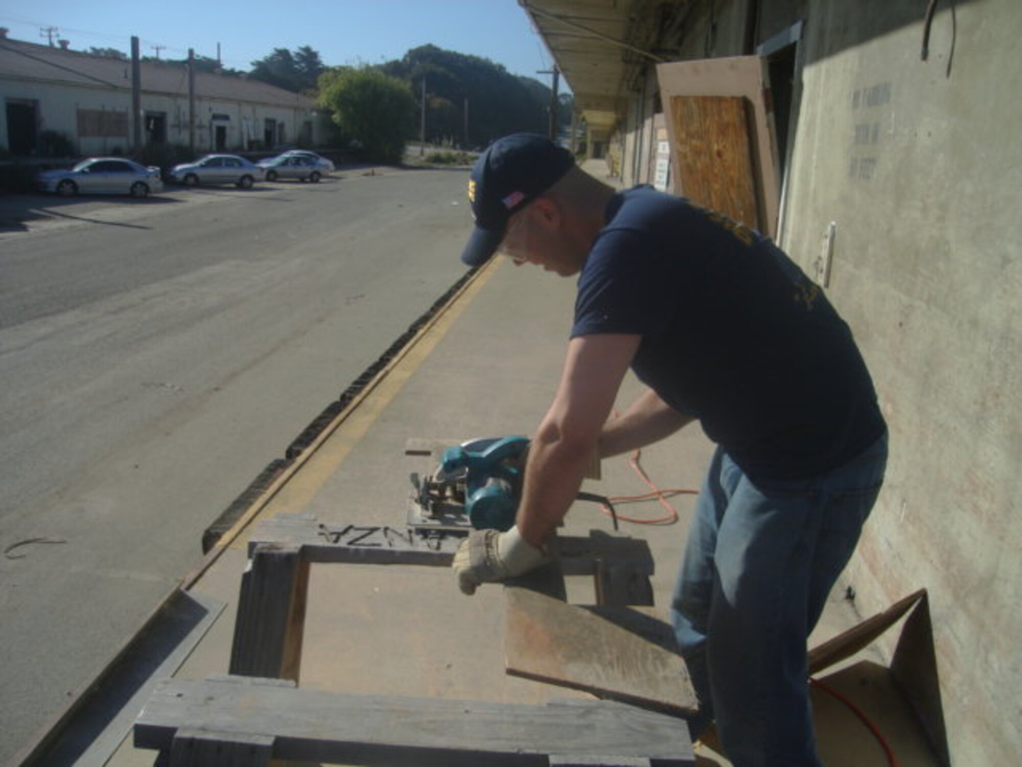 Matthew Carrell, a Chinese language student at the 311th Training Squadron at the Presidio of Monterey, Calif., cuts scrap wood May 3 to build shelves to better organize the Habitat for Humanity warehouse (U.S. Air Force photo by Staff Sgt. Damian Davies).
