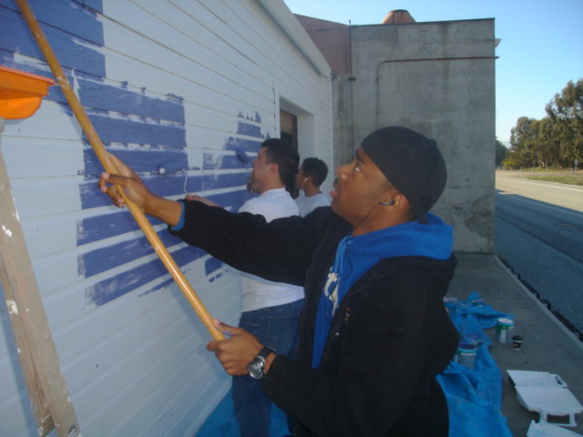 Painting the new Habitat for Humanity warehouse in Monterey, Calif. May 3 are (from front to back), Airmen 1st Class Justin Holliday and Chey Tomsu, Chinese language students at the 311th Training Squadron, and Airman 1st Class Vanessa Fountain, a Pashto language student with the 311 TRS. (U.S. Air Force photo by Staff Sgt. Damian Davies)