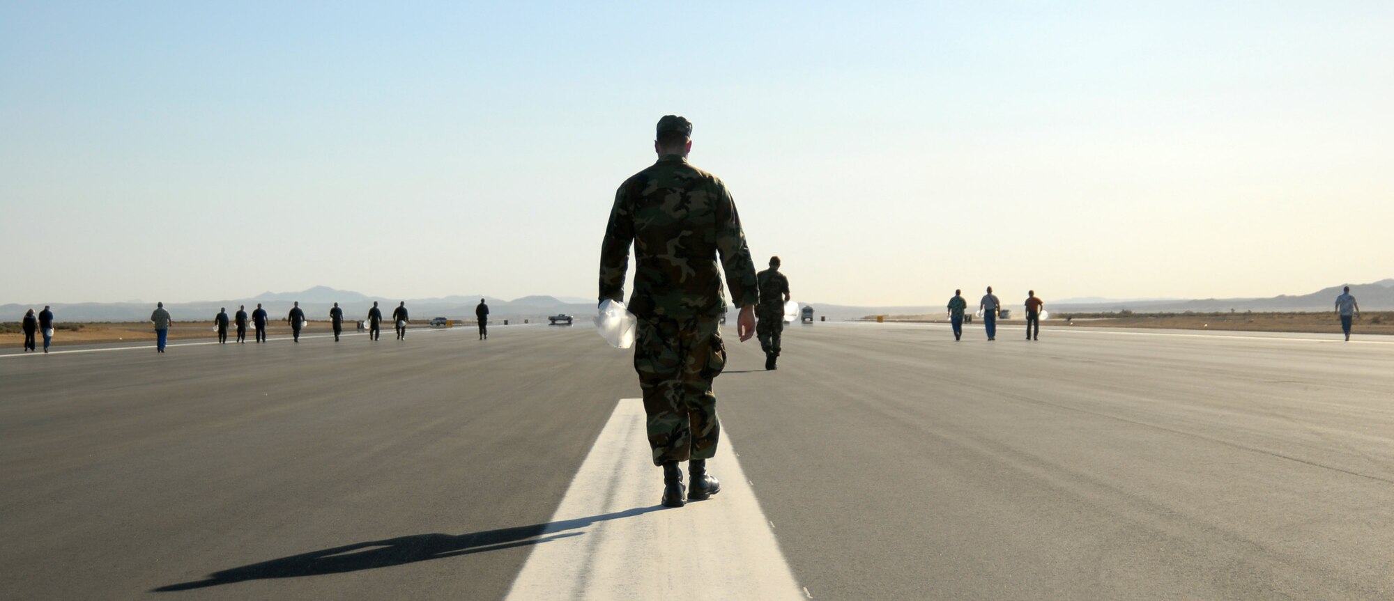 Edwards Airmen walk the new 12,000-foot long temporary main runway here during a foreign-object-debris walk on May 16. The temporary runway will be used while the U.S. Army Corps of Engineers conducts a $103 million project to replace the majority of the 50-plus-year old primary runway 04/22. (Air Force photo by Senior Airman Julius Delos Reyes)