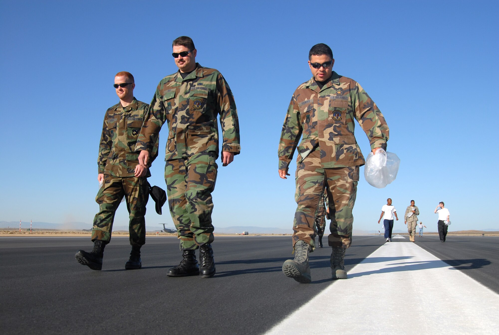 Edwards Airmen walk the new 12,000-foot long temporary main runway here during a foreign-object-debris walk on May 16. The temporary runway, which became operational May 19, will be used while the U.S. Army Corps of Engineers conducts a $103 million project to replace the majority of the 50-plus-year old primary runway 04/22. (Air Force photo by Senior Airman Julius Delos Reyes)