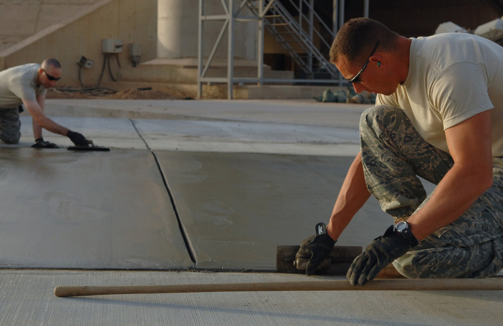 BALAD AIR BASE, Iraq -- Tech. Sgt. Adam Brothers, (right) 332nd Expeditionary Civil Engineer Squadron heavy equipment, and Master Sgt. Brian Nolan, 332 ECES heavy repair noncommissioned officer in charge, edge a new pad here, May 13. In less than four months, Balad 'Dirt Boyz,' have placed and finished more than 12,460 feet of concrete and added approximately 90,000 square feet of pavement to the airfield. Sergeant Brothers is deployed from Patrick Air Force Base, Fla.; Sergeant Nolan is deployed from Ellsworth Air Force Base, S.D. (U.S. Air Force photo/ Senior Airman Julianne Showalter)