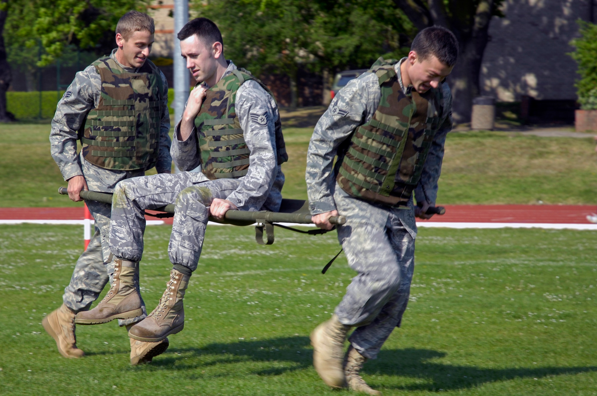 Senior Airman Grant Betts and A1C Meldion Shehu carry Staff Sergeant John Smith, 48th Security Forces Squadron May. 13 at RAF Lakenheath. The litter carry was one of the tasks during the combat challenge. Sergeant Smith's team was the fastest out of the other teams. (U.S. Air Force photo by Airman Perry Aston)