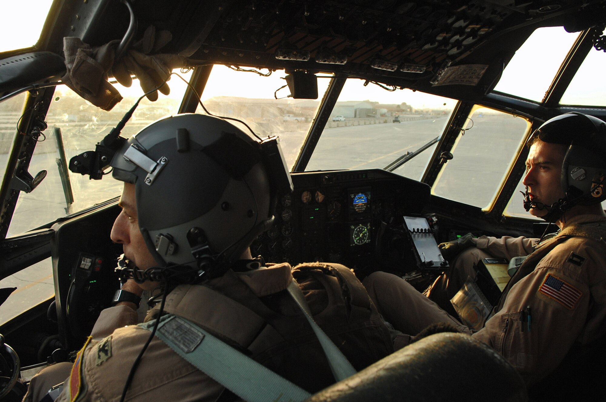 Col. Donald Kimminau and Capt. Jesse Caldwell look on as cargo is brought up to the aircraft for loading May 7 at Balad Air Base, Iraq. Members of the 777th Expeditionary Airlift Squadron help prevented convoy vehicles and servicemembers from traveling along improvised explosive device-laden Iraqi roads by airlifting troops and supplies throughout the area of operations. Colonel Kimminau is the 332nd Expeditionary Operations Group deputy commander deployed from Maxwell Air Force Base, Ala., and Captain Caldwell is a 777th Expeditionary Airlift Squadron aircraft commander deployed from Little Rock AFB, Ark. (U.S. Air Force photo/Senior Airman Julianne Showalter) 
