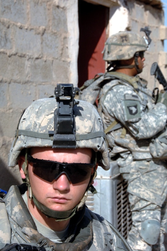 U.S. Army soldiers assigned to the 101st Airborne Division, 3rd Brigade Combat Team, scan the area for enemy movement while other soldiers search a nearby home in Yusifiyah, Iraq, on May 11th, 2008. 