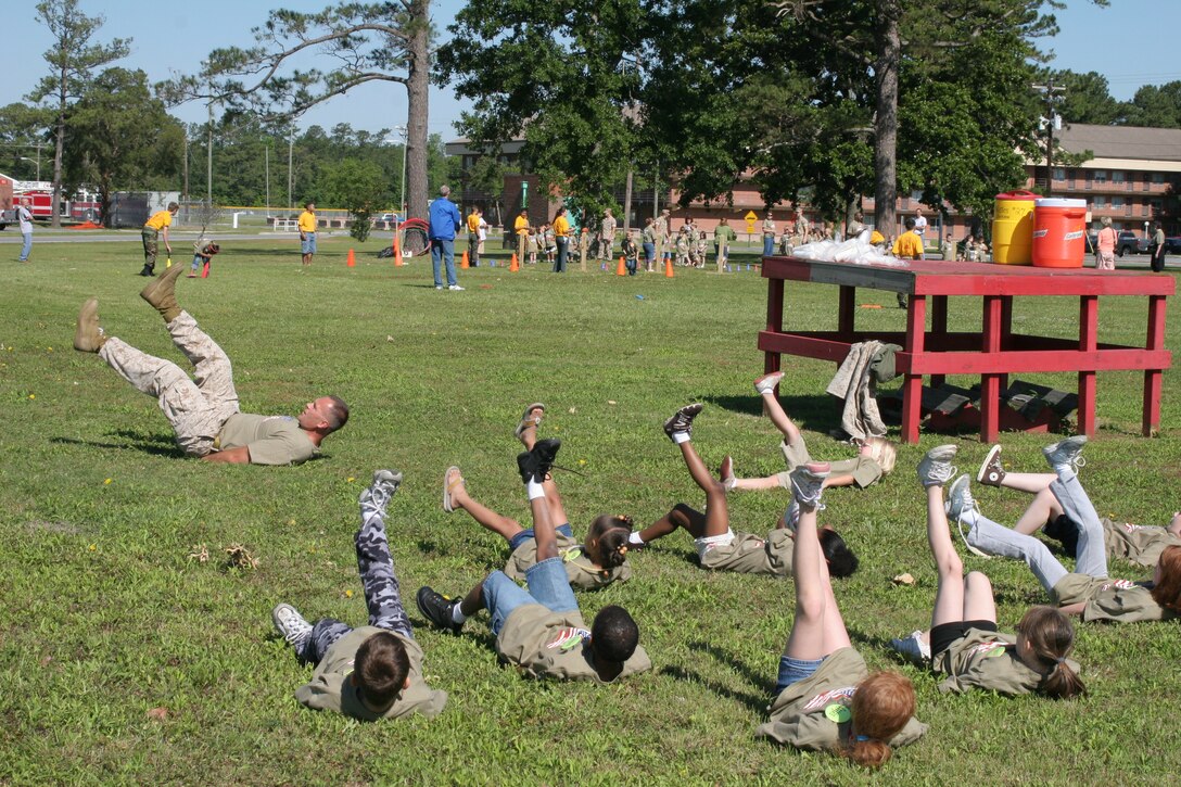 Sgt. Maj. John H. Halpin, Marine Transport Squadron 1 sergeant major, leads physical training for a group of children on Deployment Discovery Day, May 17.