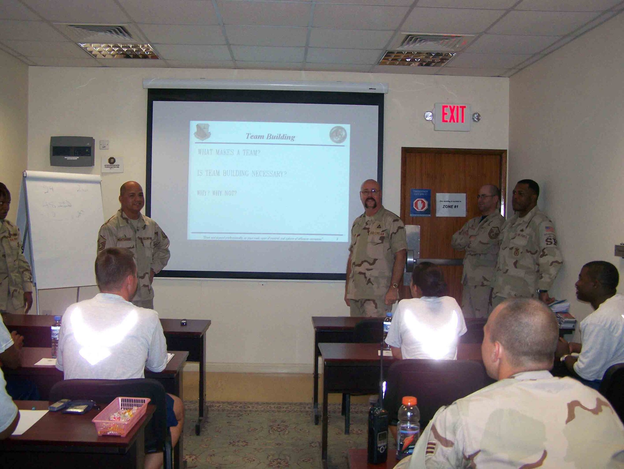 SOUTHWEST ASIA--379th Expeditionary Force Support Squadron Airman Readiness Center instructors, Master Sgt. Meril Monteagudo, left, and Barry Wilkinson give a team building brief to more than 10 servicemembers at the ARC classroom May 16. The ARC is one of its kind in the Air Forces Central area of responsibility.  It provides deployed servicemembers valuable resources to help with reintegration, financial management, leadership and other classes designed to help cope with deployments. (Courtesy photo)
