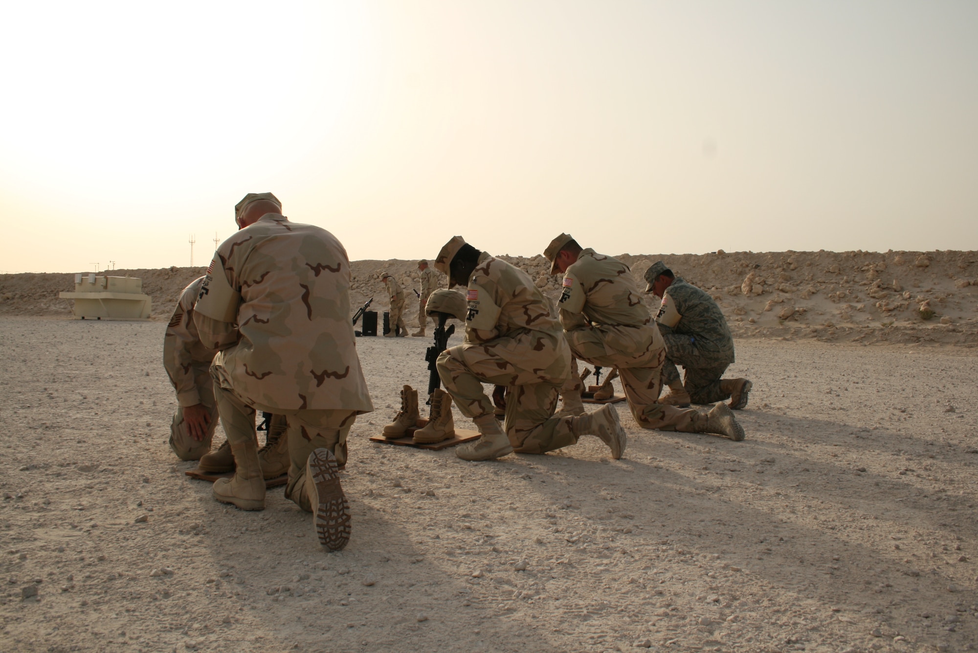 Members of the 379th Expeditionary Security Forces Squadron offer a farewell prayer and last goodbye to fellow security forces and office of special investigation brethren.  The 379th ESFS conducted a “Final Guardmount” May 15 to honor fallen U.S. Security Forces defenders during National Police Week. (U.S. Air Force photo/Senior Airman Travis Acevedo)