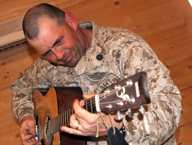 Petty Officer 1st Class Boyd W. Lewis, 41, from Willisburg, Ky., who is a religious programs specialist with Regimental Combat Team 5, tunes up his guitar to practice some new songs for the service on Sunday at the Camp Ripper chapel on Al Asad Air Base, Iraq, May 19. Lewis used to be in a 'trailer-park punk' band called Bug Eyed Rachel. He now plays for the protestant praise-and-worship band at Camp Ripper and is planning on starting his own punk Christian band.