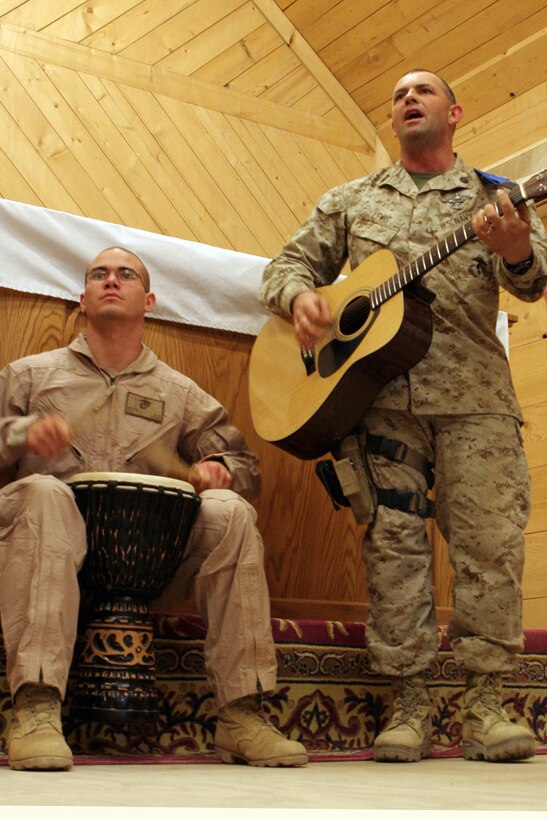Petty Officer 1st Class Boyd W. Lewis, 41, from Willisburg, Ky., who is a religious programs specialist, sings as Cpl. Andrew Nelson, an ammo tech, plays the drum at a praise and worship band practice at the Camp Ripper chapel on Al Asad Air Base, Iraq, May 19. Both are assigned to Regimental Combat Team 5. Lewis used to be in a 'trailer-park punk' band called Bug Eyed Rachel. Lewis got his passion for music from his father.  Lewis plans on starting a punk Christian band someday.