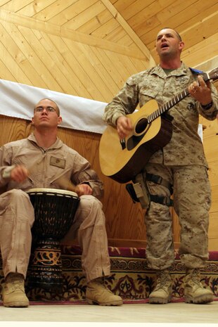Petty Officer 1st Class Boyd W. Lewis, 41, from Willisburg, Ky., who is a religious programs specialist, sings as Cpl. Andrew Nelson, an ammo tech, plays the drum at a praise and worship band practice at the Camp Ripper chapel on Al Asad Air Base, Iraq, May 19. Both are assigned to Regimental Combat Team 5. Lewis used to be in a 'trailer-park punk' band called Bug Eyed Rachel. Lewis got his passion for music from his father.  Lewis plans on starting a punk Christian band someday.