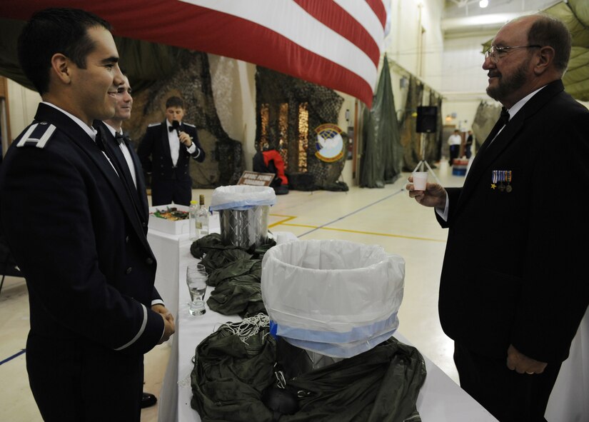 MOODY AIR FORCE BASE, Ga. -- Jim Beggerly, right, Society of Combat Search and Rescue president, receives a beverage from the "grog" during the 347th Rescue Group dining out here May 16.  The dining out was the final event of the CSAR Symposium held here May 14-16. (U.S. Air Force photo by Senior Airman Gina Chiaverotti) 
