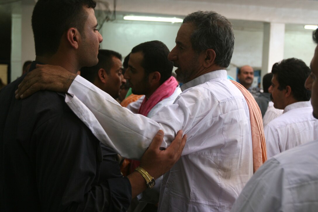 An Iraqi man speaks with an Iraqi Police Officer May 18, at the Iraqi Police Station in Karma, before he is released back to his family. Approximately 40 Iraqis were released after being fully screened and prepped to return home.