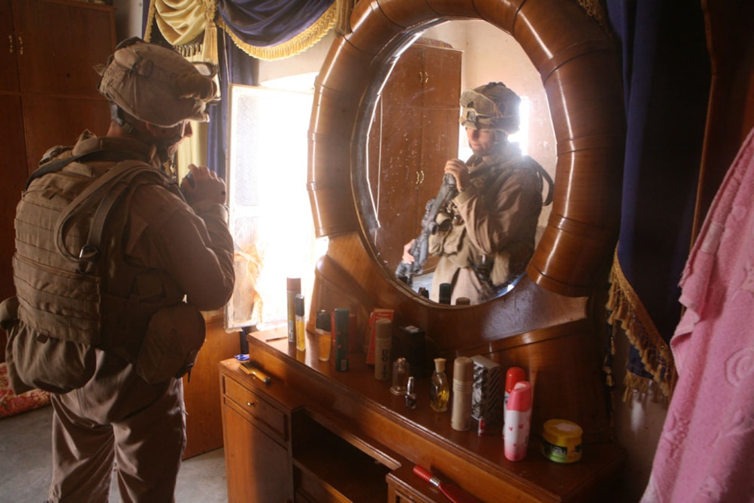 During a search of an Iraqi house, Pfc. Bradley R. Clifton, 18, a scout from Frankfort, Ky., with Delta Company, 2nd Light Armored Reconnaissance Battalion, Regimental Combat Team 5, glances at a wooden dresser May 18. The company, known as â??Outlaw,â?? operates in the outskirts of Rutbah, Iraq. They greet the residents, making certain the area is clear of danger while handing out water, food and collecting feedback on livestock and supplies needed for the crops or sheep.