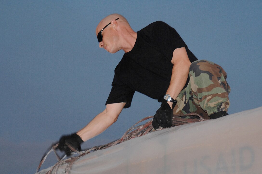 Utapao, Thailand - Technical Sgt James Glickman unstraps cargo netting during the download of humanitarian relief supplies being delivered to Burma May 16. TSgt Glickman is forward deployed with the 36th Contingency Response Squadron from Andersen AFB, Guam. (USAF photo/Senior Airman Sonya Croston)(RELEASED)
