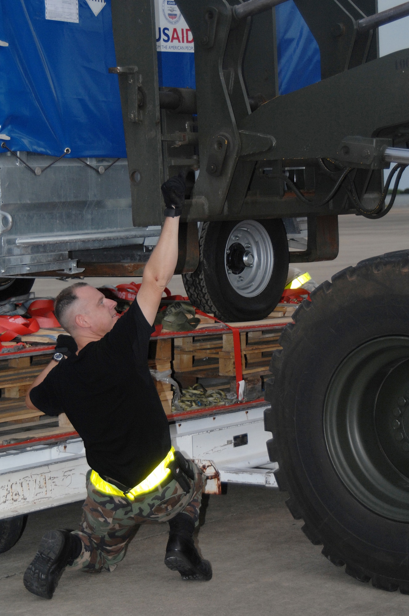 Utapao, Thailand - Technical Sgt John Kortez, 36th Contingency Response Squadron from Andersen AFB, Guam directs the placement of a forklift for the transfer of humanitarian relief supplies being downloaded from a Boeing 747 commercial airplane for delivery into Burma May 16. (USAF photo/Senior Airman Sonya Croston)(RELEASED)
