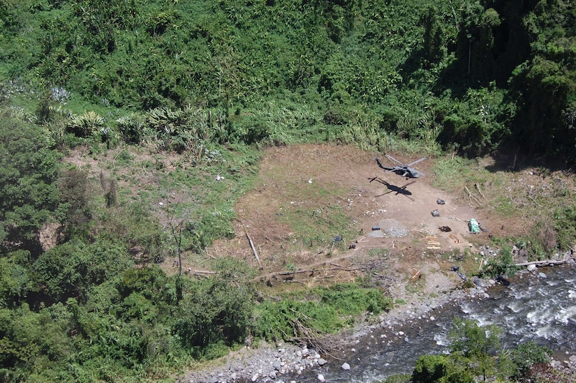 A Joint Task Force-Bravo UH-60 Black Hawk helicopter drops off bridge building materials at a remote site in Costa Rica. The 16-person team performed 38 lifts to three different building sites.
