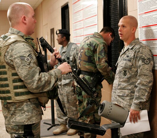 NELLIS AIR FORCE BASE, Nev.—Staff Sgt. Chris Shubik and Senior Airman Ryan Welton, both 99th Security Forces Squadron patrolmen, verify Airman Welton’s M-4 rifle is safe and clear while arming up for duty here May 13. Security forces patrolmen possess a wide array of weapons during their patrols to accomplish their mission. (U.S. Air Force photo/Staff Sgt. Jacob R. McCarthy)