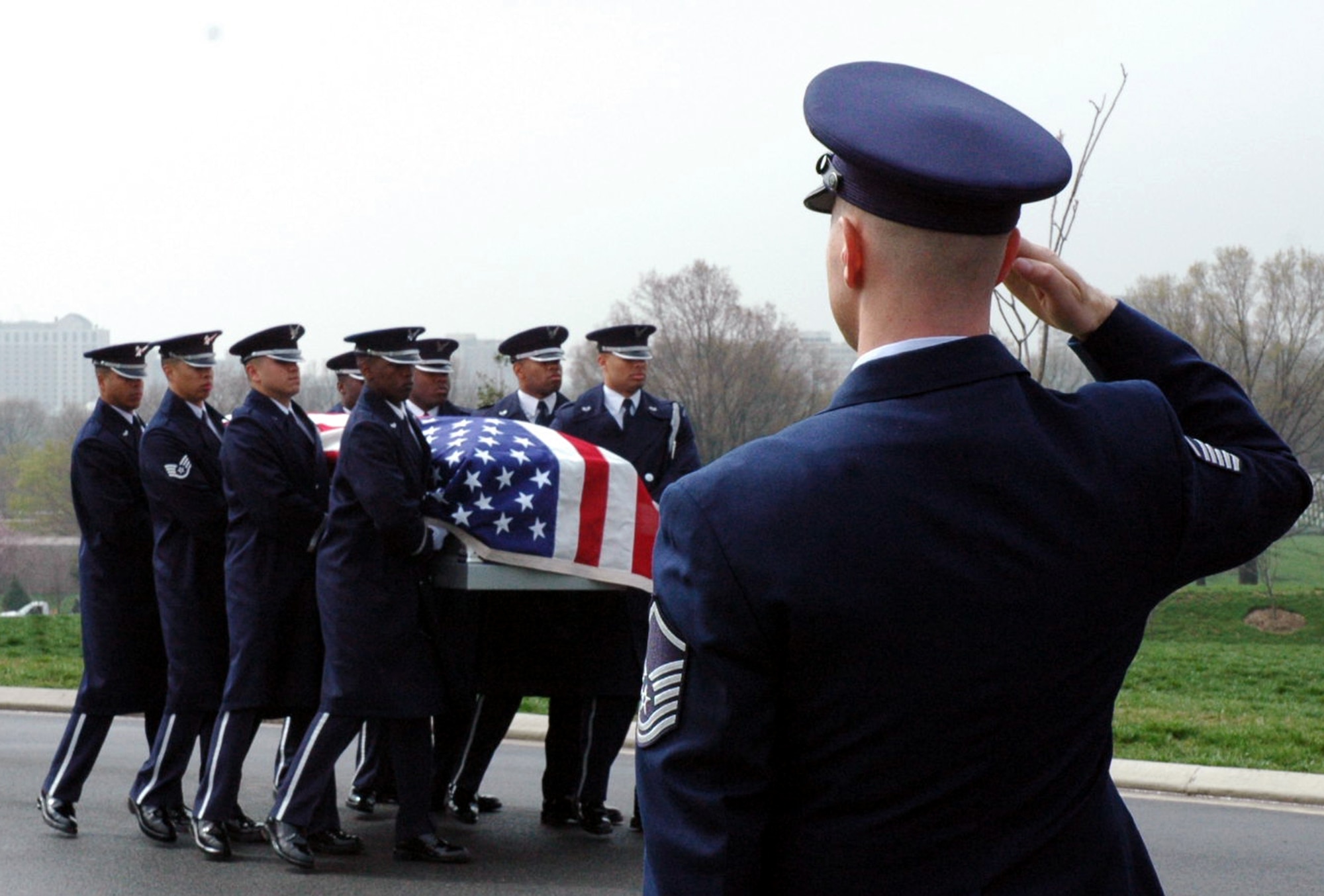 A U.S. Air Force master sergeant salutes while eight members of the U.S. Air Force Honor Guard from Bolling Air Force Base, D.C., carry the casket of Maj. Robert F. Woods to a horse-drawn caisson during the funeral for Major Woods at Arlington National Cemetery, Va., April 9, 2008.  Major Woods's funeral came nearly 40 years after he disappeared on June 26, 1968, in Vietnam.  The Department of Defense announced the postive identification of his remains in a Nov. 30, 2007, announcement.  (U.S. Air Force Photo/Tech. Sgt. Scott T. Sturkol)