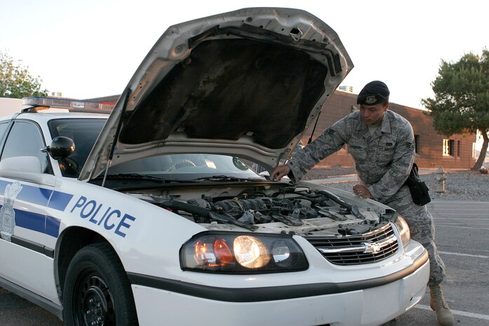 NELLIS AIR FORCE BASE, Nev.—Senior Airman Anthony Lanzon, 99th Security Forces Squadron patrolman, checks his patrol vehicle after receiving it during shift change here May 13. Every 12-hour shift starts and end this way to keep vehicles running at peak performance. (U.S. Air Force photo/Staff Sgt. Jacob R. McCarthy)