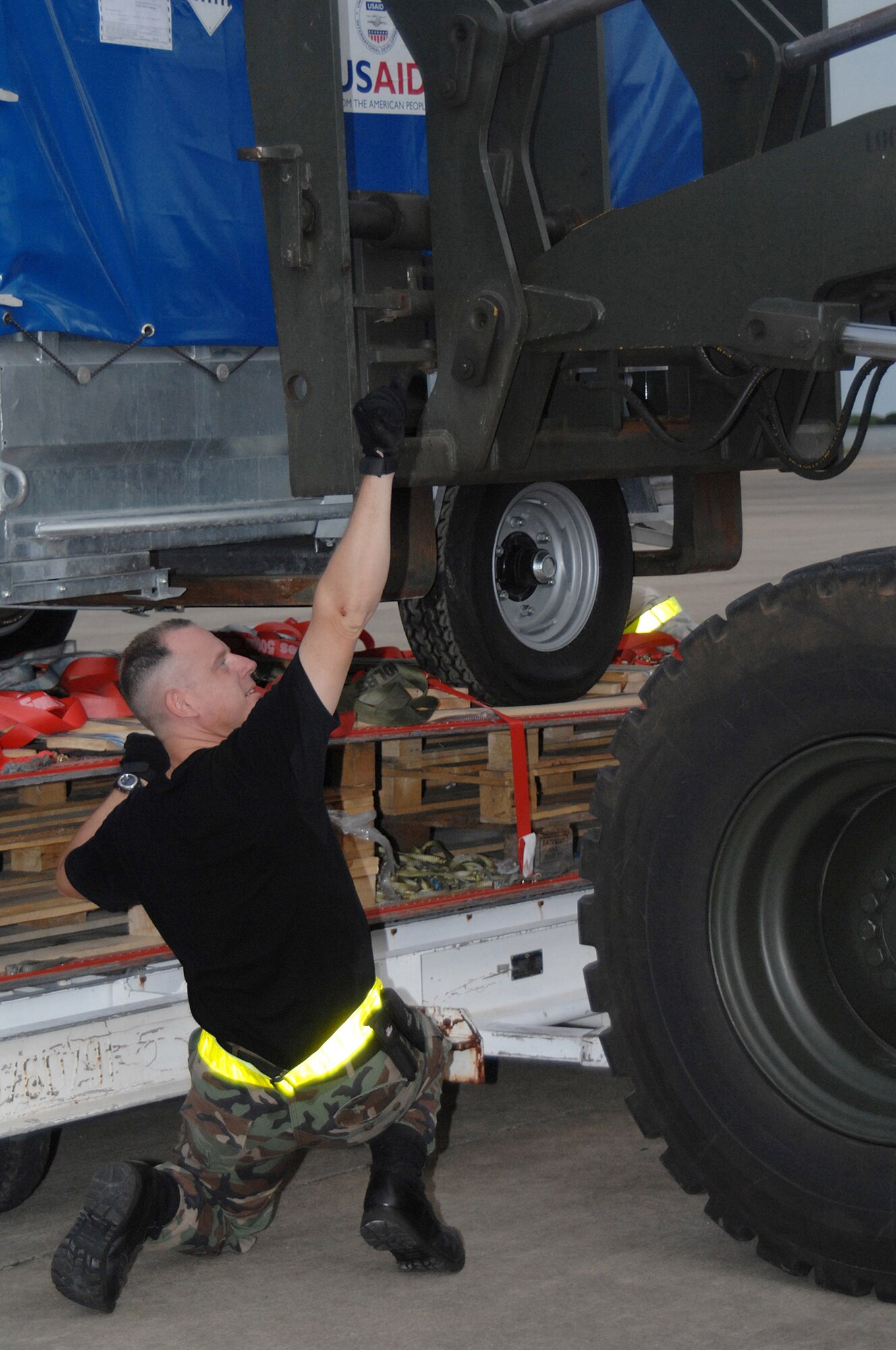 Tech. Sgt. John Kortez directs a forklift driver transferring humanitarian relief supplies being downloaded from a Boeing 747 commercial airplane May 16 at Utapao Thai Royal Navy Air Base, Thailand, for delivery to Burma.  Sergeant Kortez is with the 36th Contingency Response Squadron at Andersen Air Force Base, Guam.  (U.S. Air Force photo/Senior Airman Sonya Croston)