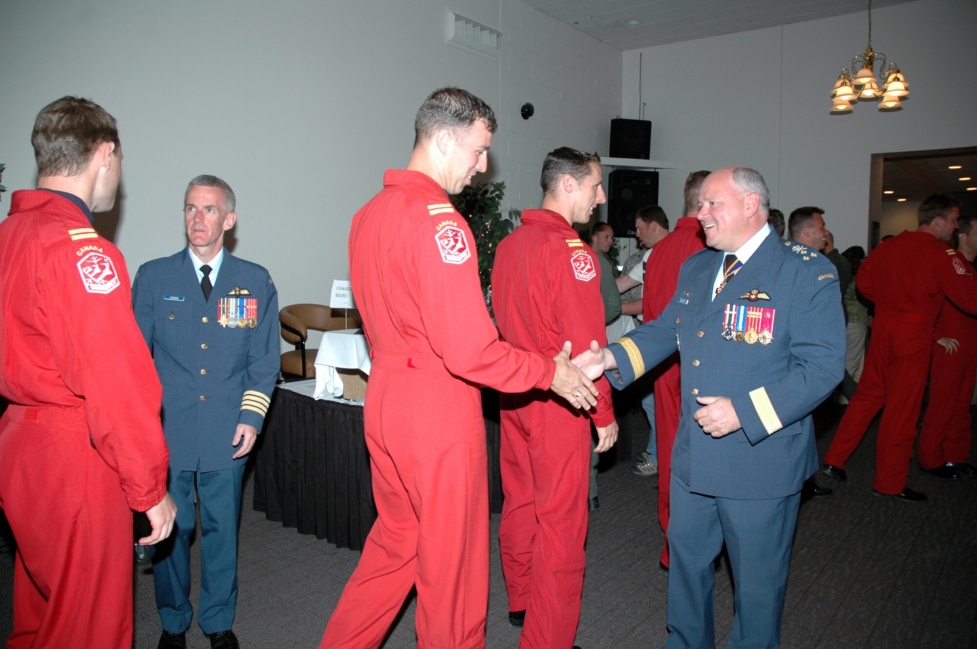 Col. Richard Foster, 15 Wing Moose Jaw commander, and Lt. Gen. Charles Bouchard, NORAD deputy commander, greet the Canadian Forces Snowbirds aerial demonstration crew pilots as they enter the Grizzly Bend Club May 17. A social was held there to honor the Snowbirds and highlight the eternal bond between Malmstrom and the Canadian Forces following last year's fatal crash of Capt. Shawn McCaughey, Canadian Forces Snowbirds pilot, whos aircraft went down during a practice for last year's open house. (U.S. Air Force photo/Airman 1st Class Emerald Ralston)
