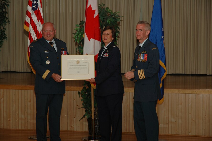 Lt. Gen. Charles Bouchard, North American Aerospace Defense Command deputy commander, and Col. Richard Foster, 15 Wing, Moose Jaw, Saskatchewan, commander,  present Col. Sandy Finan, 341st Space Wing commander with the Chief of Defense Staff recognition commendation at the Grizzly Bend Club May 17 for Malmstrom's support  and service following the fatal crash of Capt. Shawn McCaughey, Canadian Forces Snowbird pilot, before last year's Open House. Malmstrom is one of only five units outside the Canadian Forces to recieve this honor. (U.S. Air Force photo/Airman 1st Class Emerald Ralston)