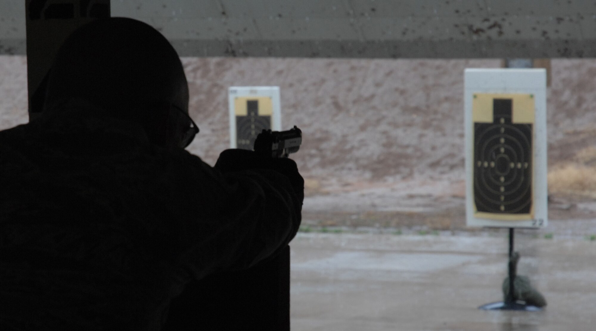 CANNON AIR FORCE BASE, N.M. - An Airman is silhouetted while shooting a target during the pistol shoot May 14. The event was a part of National Police Week, the week of May 15. (U.S. Air Force photo/Airman 1st Class Evelyn Chavez)