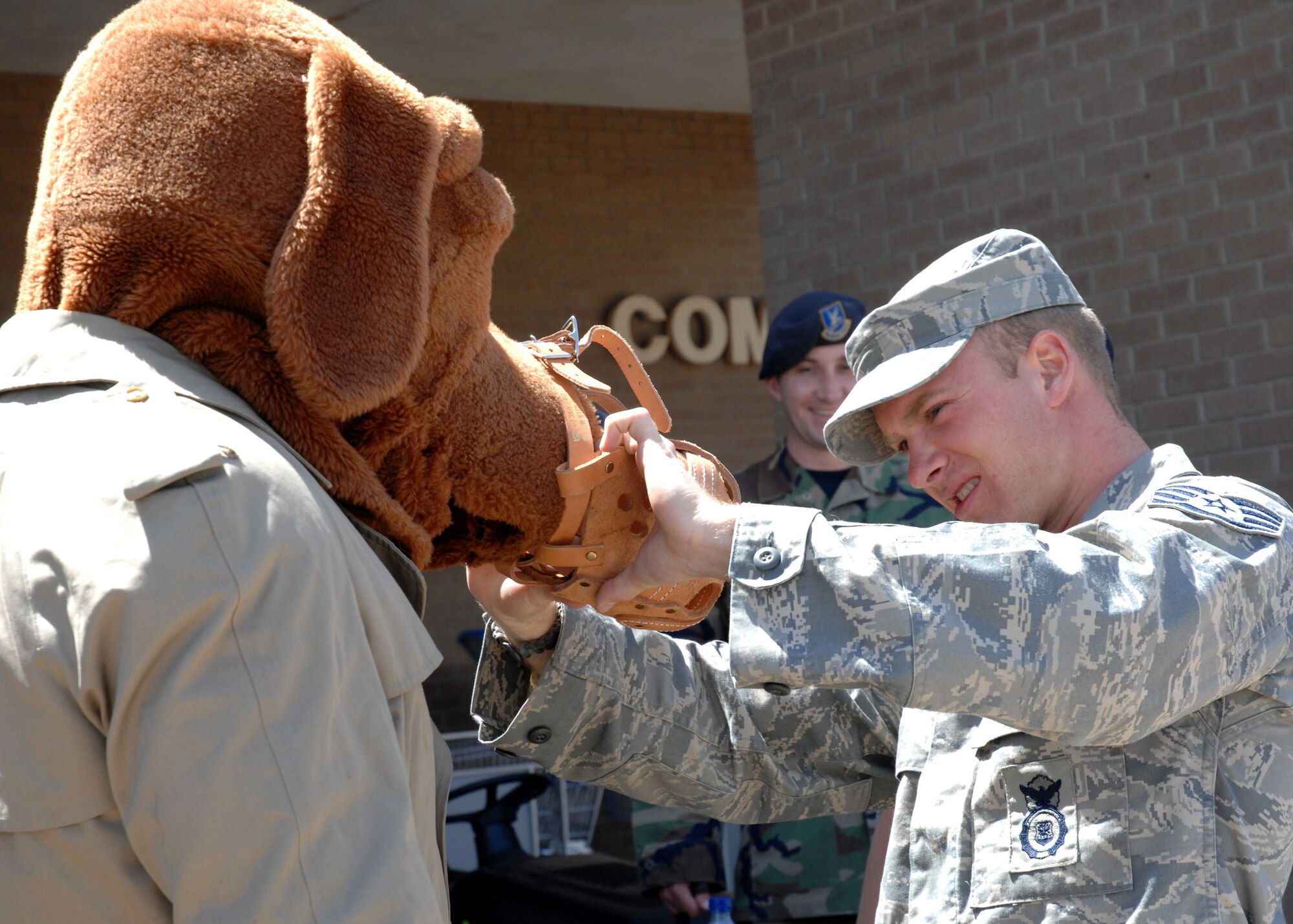 CANNON AIR FORCE BASE, N.M. - Staff Sgt. Anthony Pace, 27th Special Operations Security Forces Squadron, fits McGruff the Crime Dog with a muzzle at the security forces display at the Base Exchange May 13. The event was part of National Police Week, the week of May 15. (U.S. Air Force photo/Airman 1st Class Evelyn Chavez)