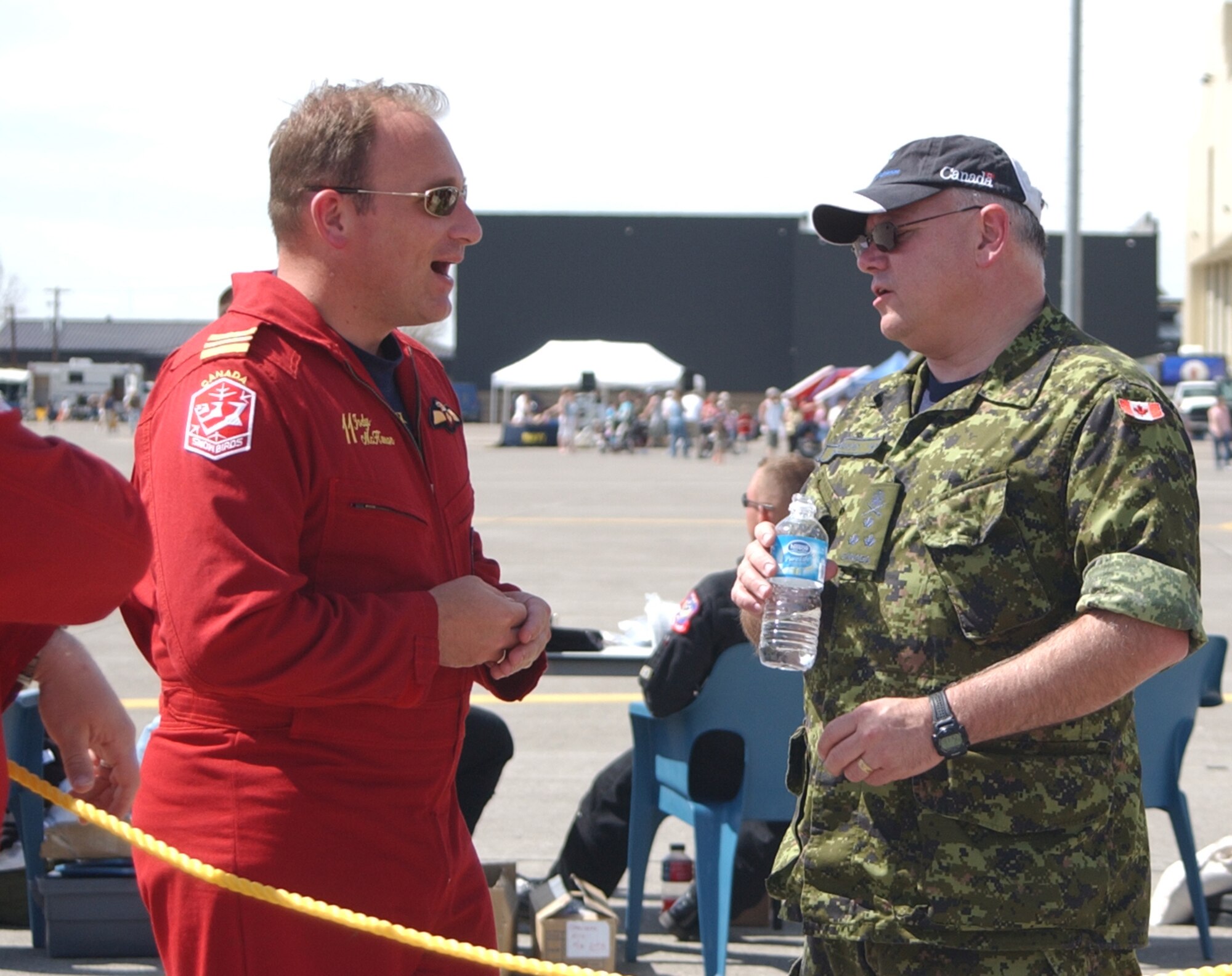Lt. Gen. Charles Bouchard, North American Aerospace Defense Command deputy commander, and Maj. Jody McKinnon, Canadian Snowbirds team coordinator,  share a conversation before the Snowbirds performance at Malmstrom Air Force Base, Mont., May 17. General Bouchard was on hand to present an award to Malmstrom at a post-air show dinner. (U.S. Air Force photo/Valerie Mullett)