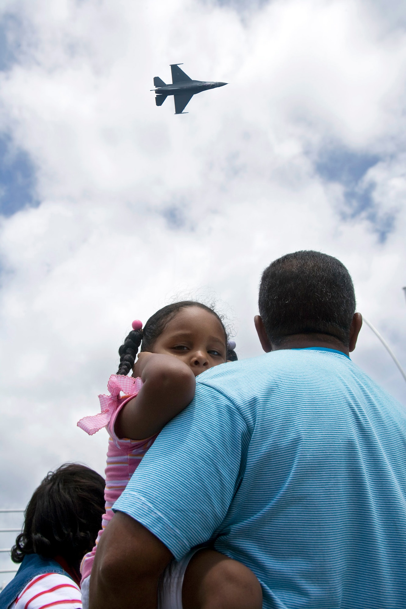 A local child covers her ears as an F-16 Fighting Falcon, flown by Capt. George Clifford of the Viper East F-16 demonstration team, flies over Curacao, Netherlands Antilles.  The Viper East team, from Shaw Air Force Base, S.C., joined officials from Air Forces Southern headquarters at Davis-Monthan AFB, Ariz., to augment "Dutch Navy Days," a celebration put on every three years by the Dutch military to honor their naval heritage and partnership with the people of Curacao. (Courtesy photo/Peter Bijpost)