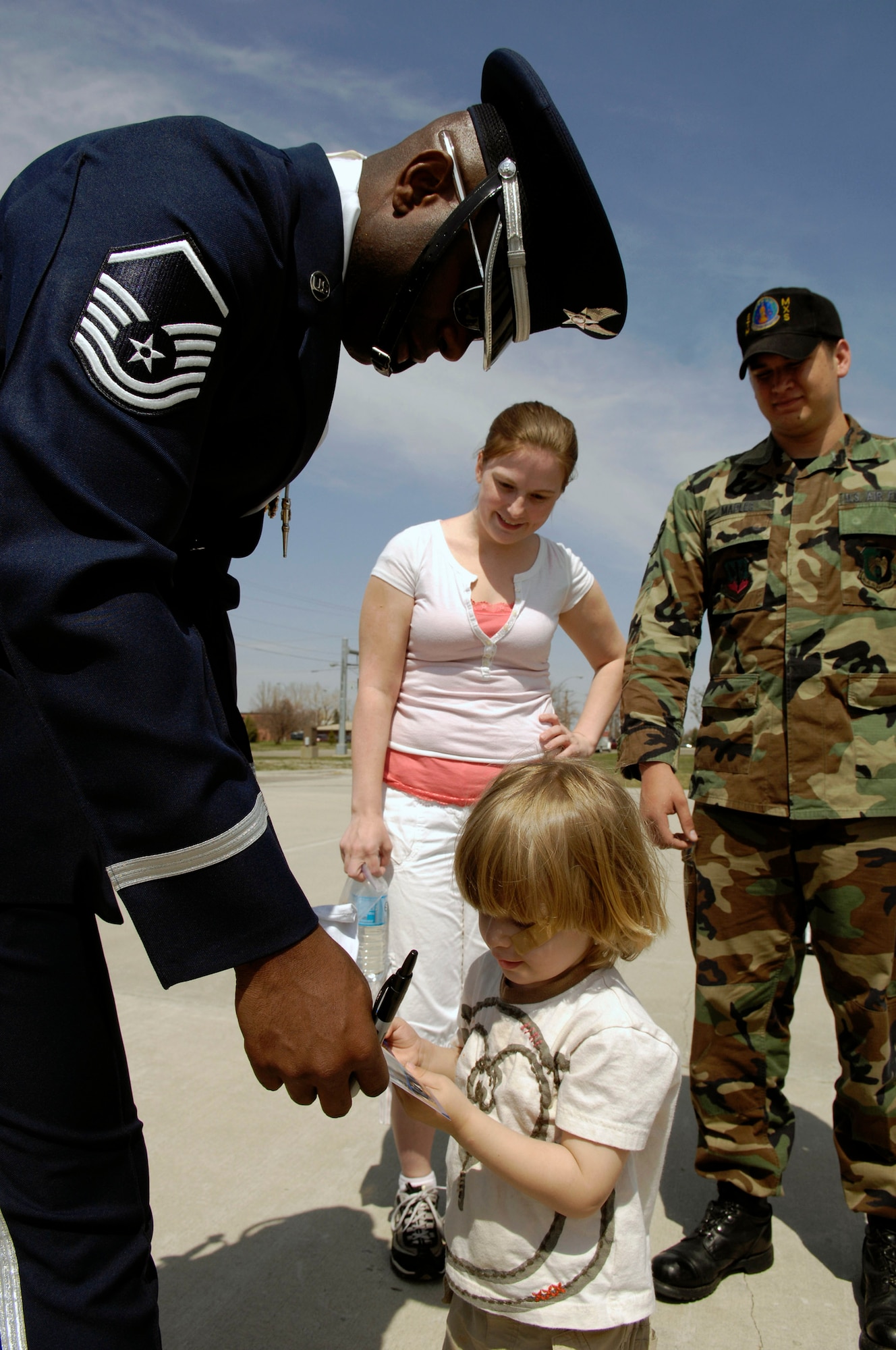 Master Sgt. Steven West writes a message for a child May 8 following the Air Force Honor Guard Drill Team's performance at Minot Air Force Base, N.D. The drill team is the traveling component of the Air Force Honor Guard and tours world-wide representing all Airmen and showcasing Air Force precision to recruit, retain and inspire for the Air Force mission. Sergeant West is the drill team superintendent. (U.S. Air Force photo/Senior Airman Dan DeCook) 