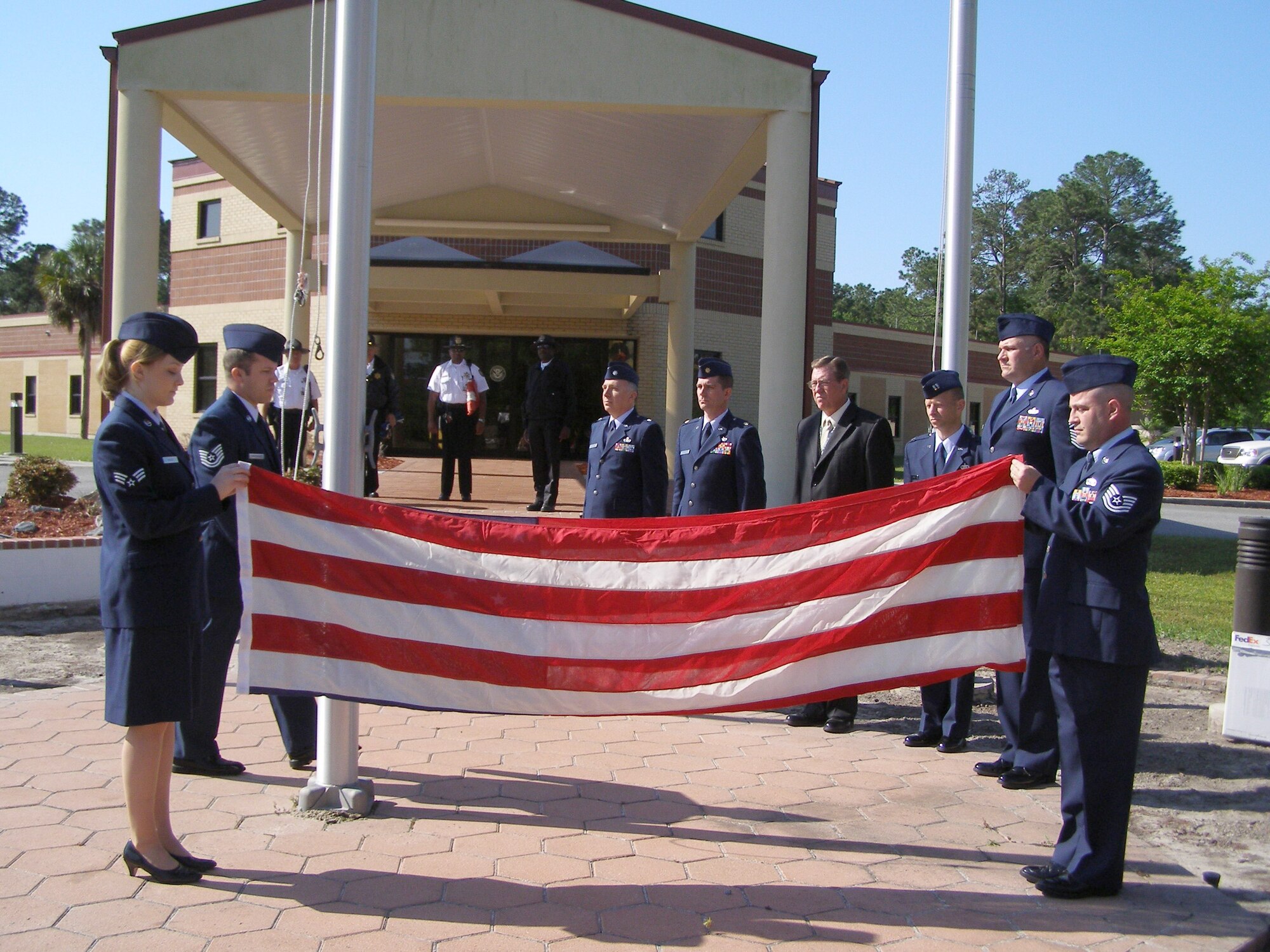 Instructors and staff of the United States Air Force Special Investigations Academy (USAFSIA) gathered at the headquarters building of the Federal Law Enforcement Training Center, Brunswick, Ga., April 14, to do their part for the Air Force Office of Special Investigation’s 60th Anniversary ceremony. Folding Flag: Left - SrA Sara McCoy, AFSIA IM; Right - TSgt Charles Meore; NCOIC, AFSIA/CSS; At Flag Pole:  TSgt Phillip Santomauro, Instructor, AFSIA Basic Division. In Rear from Left to Right:  Lt Col Nicholas Mattia, IMA to AFSIA/CC; Major Keith Crook FSC/Instructor; Mr. Jeffrey Thompson, Director, AFSIA Advanced Division; Capt. Brent Heckel, Director, AFSIA Basic Division; CMSgt Walker Cottingham AFSIA Superintendent. (Courtesy photo)