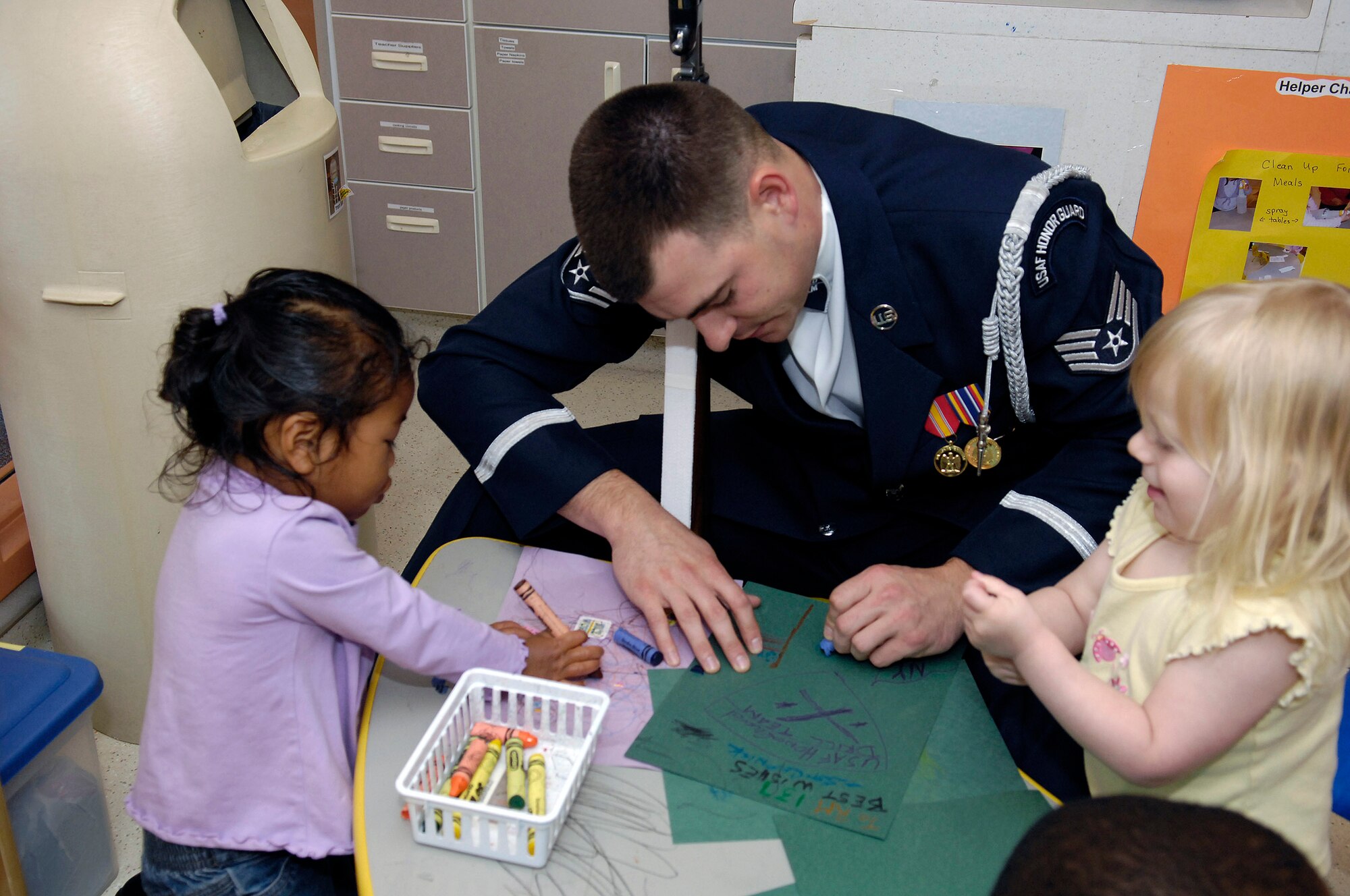 Staff Sgt. Adam Clonick colors with local children May 12 at the Ellsworth Child Development Center at Ellsworth Air Force Base, S.D. The Air Force Honor Guard Drill Team is the traveling component of the AF Honor Guard and tours world-wide representing all Airmen and showcasing Air Force precision to recruit, retain and inspire for the Air Force mission. Sergeant Clonick is the current mission coordinator. (U.S. Air Force photo/Senior Airman Dan DeCook) 