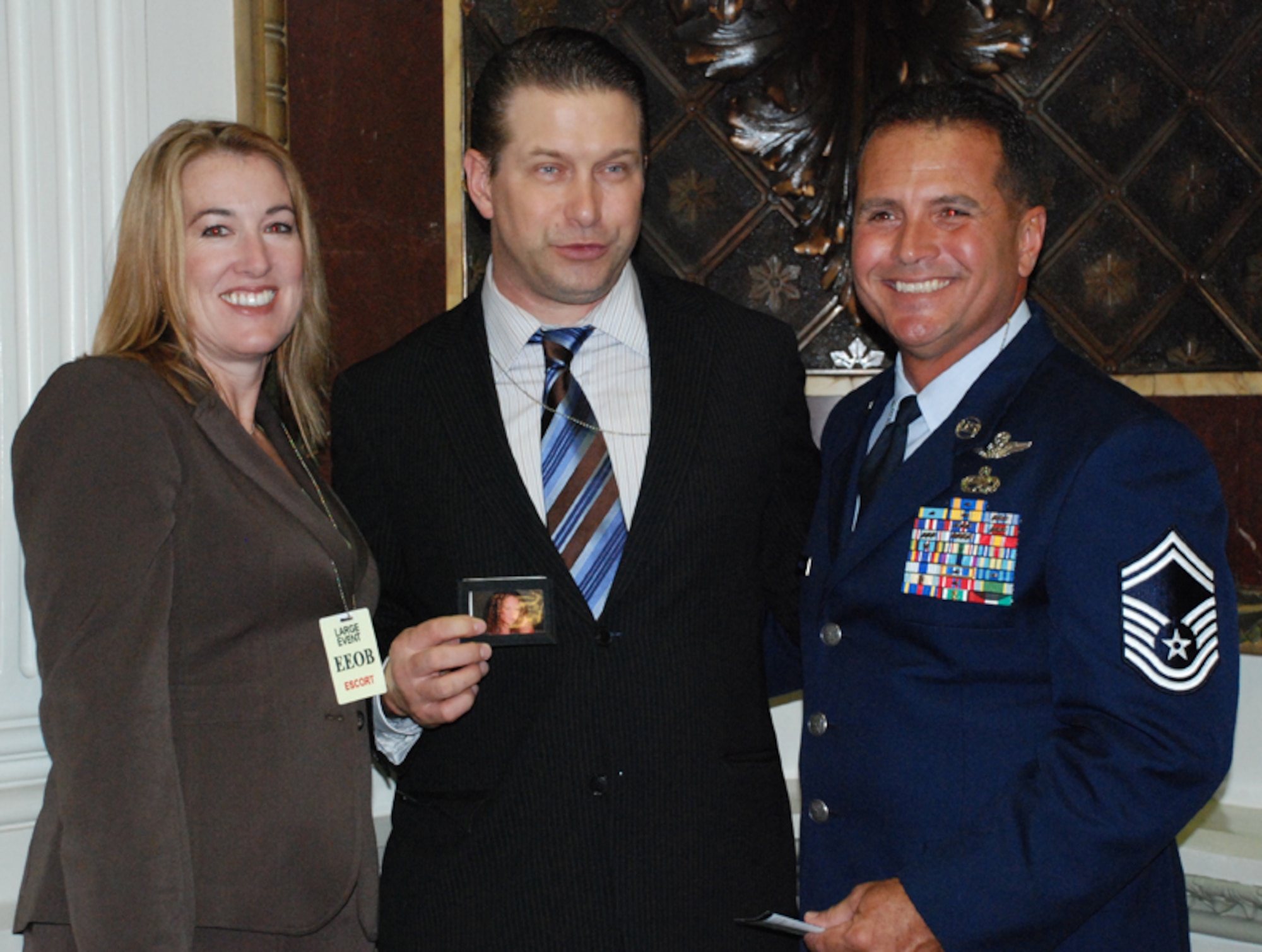 PATRICK AIR FORCE BASE, Fla. -- Senior Master Sgt. Rene Rubiella (right), recipient of the USA Freedom Corps President's Service Award, and his wife Terry, pose with Stephen Baldwin, actor and member of the President's Council on Service and Civic Participation.  The sergeant was honored during a special White House ceremony.  Baldwin is holding a photo of the Rubiella's daughter, Alexandria, who was killed in an auto accident. It was his daughter's death that led Rubiella to create Operation Not on Our Watch (NOW) to warn high school students of the dangers of careless driving. (U.S. Air Force photo/Capt. Cathleen Snow)