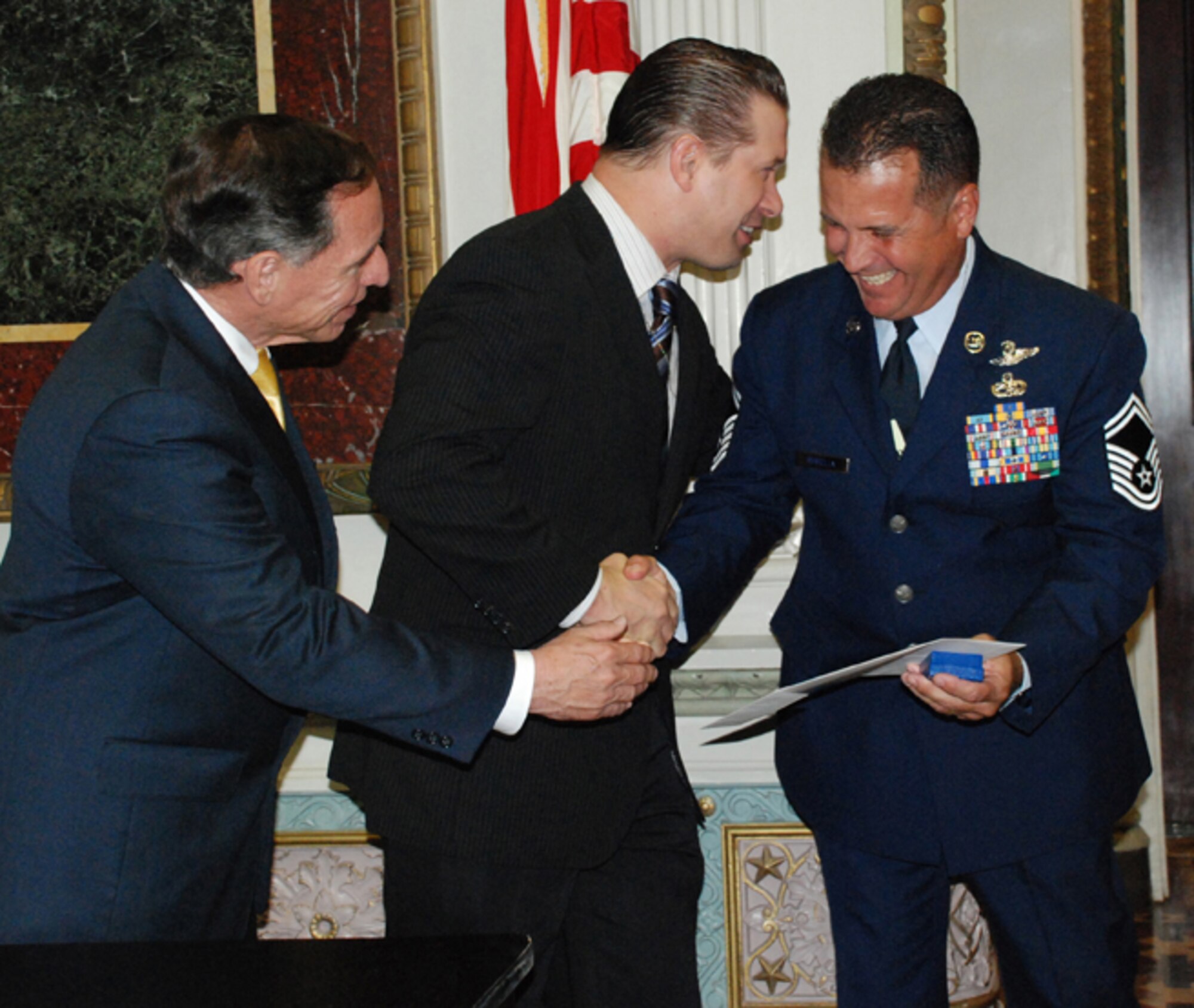 PATRICK AIR FORCE BASE, Fla. -- Senior Master Sgt. Rene Rubiella of the 920th Rescue Wing shakes hands with Stephen Baldwin (center), actor and member of the President's Council on Service and Civic Participation, and the Honorable Henry C. Lozano, Deputy Assistant to the President and Director of USA Freedom Corps, after receiving his volunteer service award at a special White House ceremony.  Sergeant Rubiella, who is the 920th Operations Group superintendent, has volunteered almost 20,000 hours of his time for various programs to enrich the local community. (U.S. Air Force photo/Cathleen Snow)