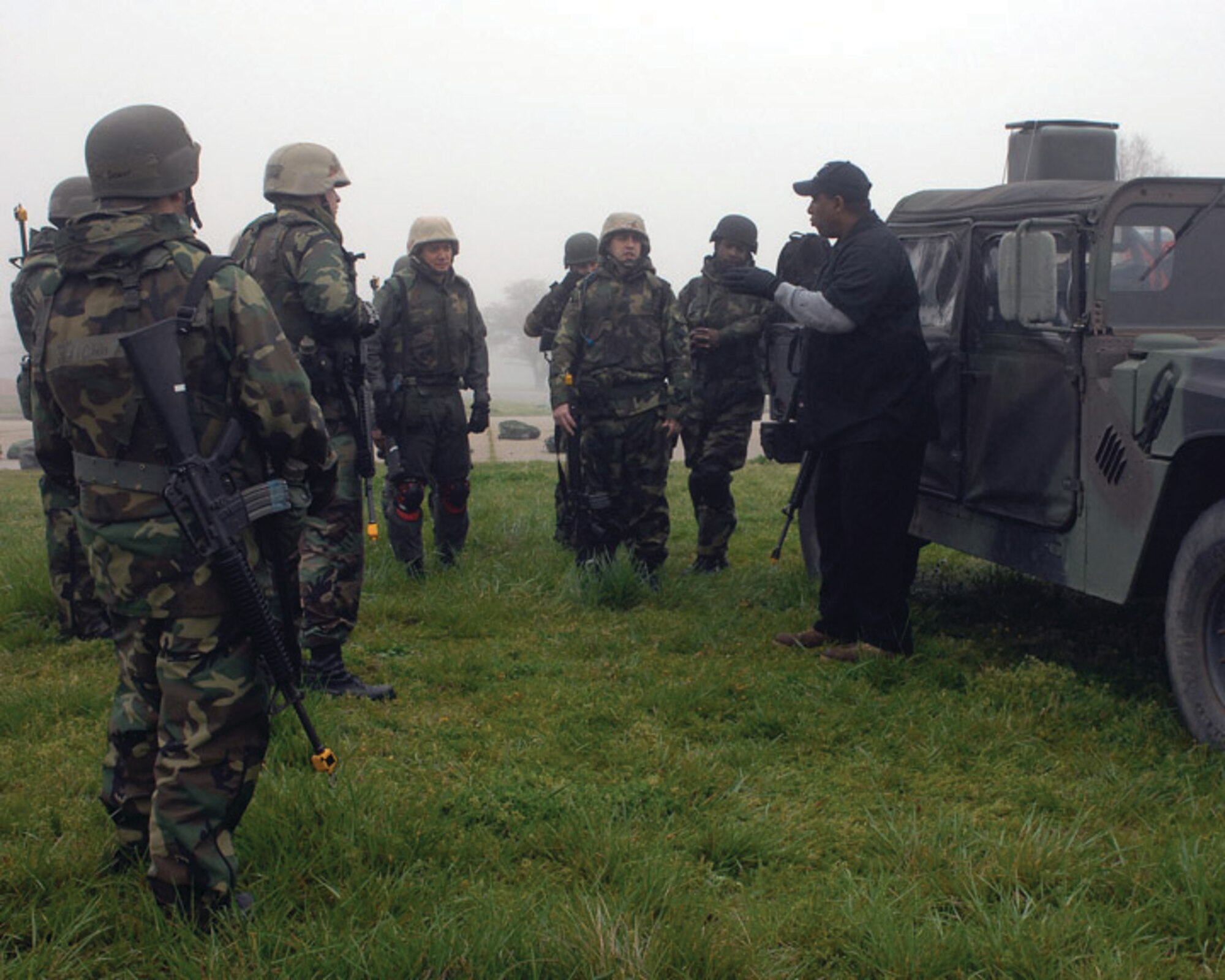 LANGLEY AIR FORCE BASE, Va. -- Mr. William Rupert, 1st Security Forces Squadron expeditionary combat skills instructor, shows Airmen how to work as partners, taking tactical deployment positions while exiting a Humvee here April 10. Combat Skills Training is a basic three-day course for deploying personnel where Airmen who are normally in noncombatant roles learn to shoot, move and communicate. (U.S. Air Force photo/Master Sgt.Carlos J. Claudio)