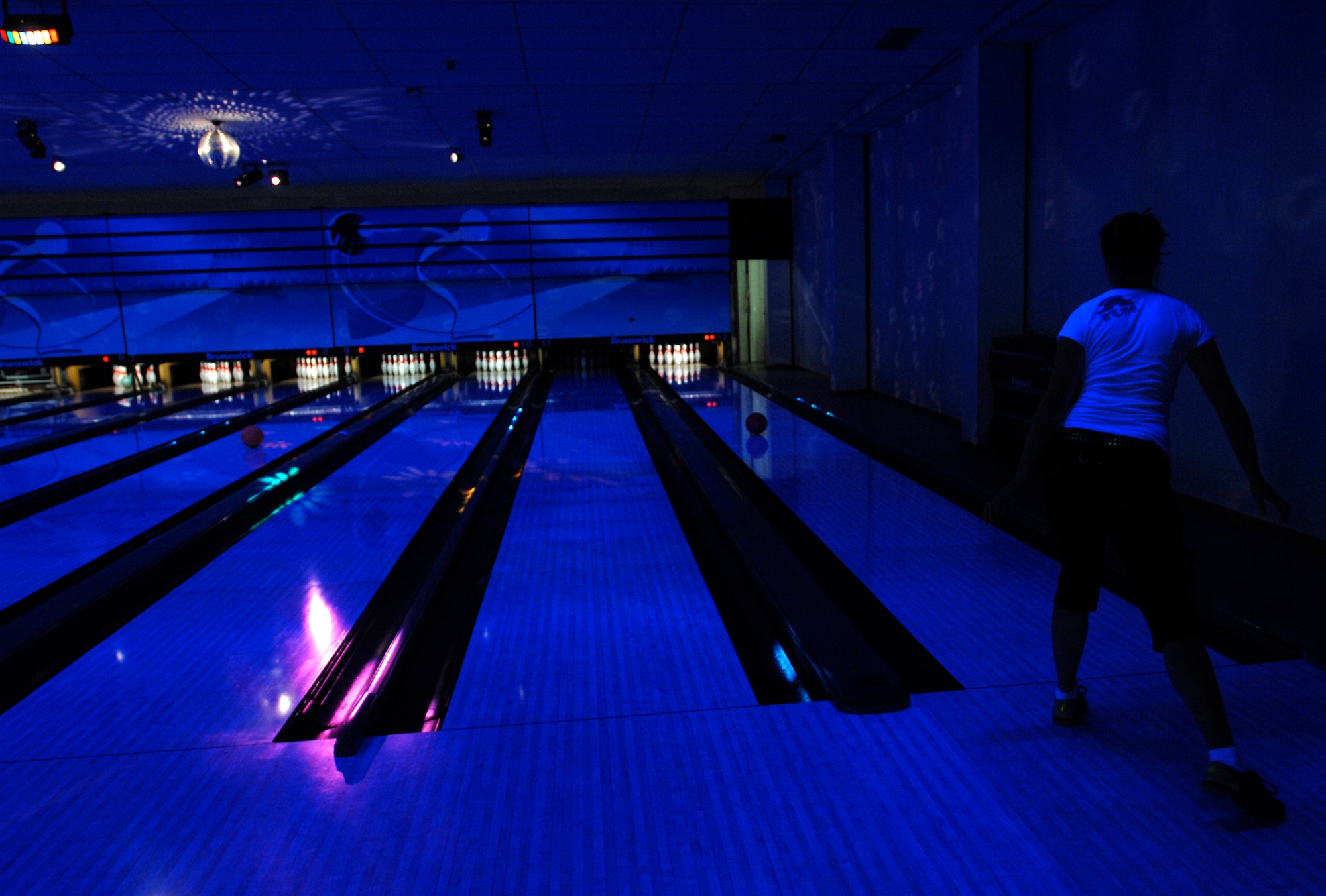 AVIANO AIR BASE, Italy --Tabitha Mans  watches in anticipation as her bowling ball rolls towards the pins May 17.  Loud music, a disco ball and black lights make up cosmic bowling at the Ten Pin Inn bowling center.  (U.S. Air Force photo/Airman 1st Class Ashley Wood)